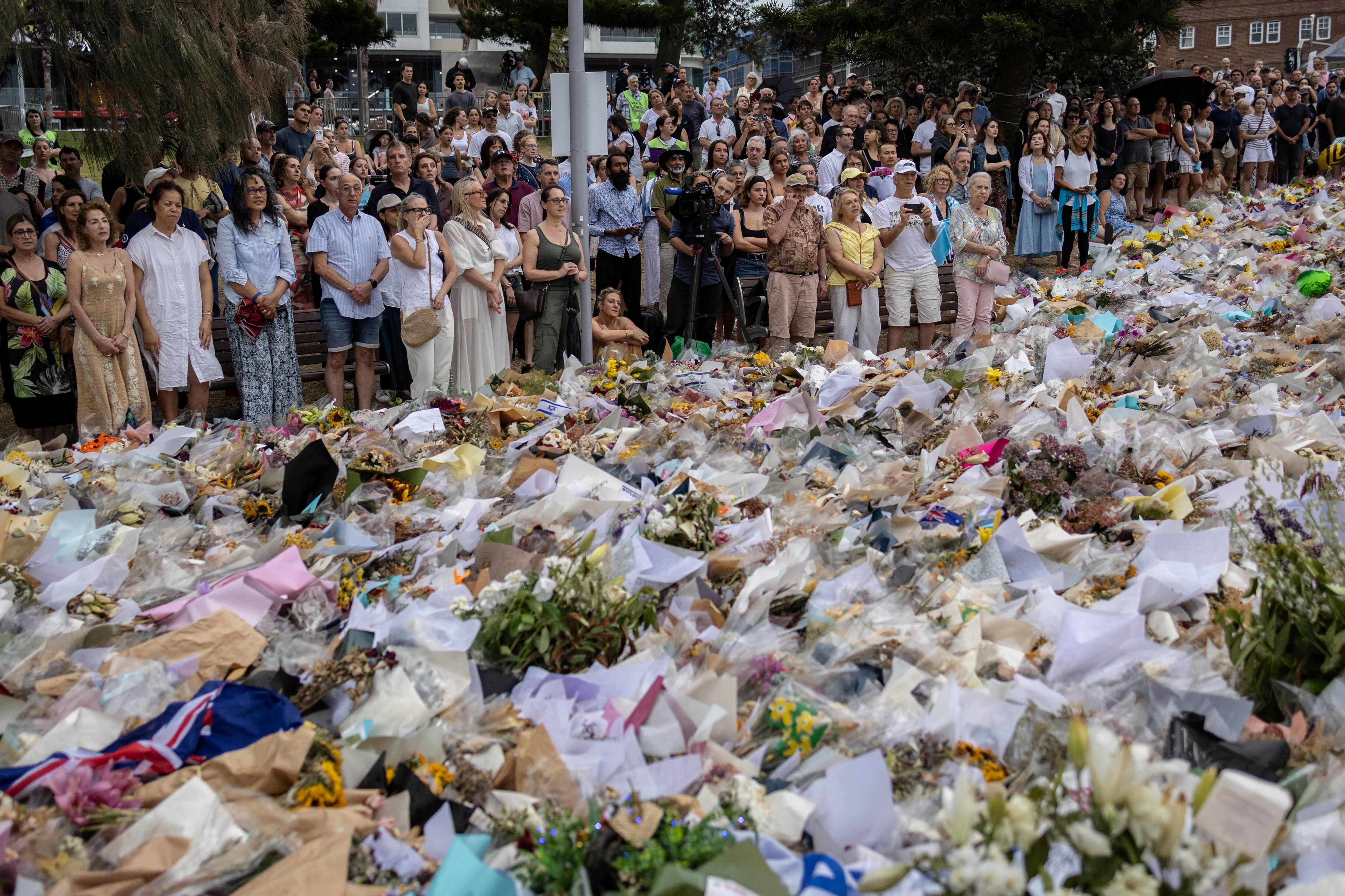 People gather around offered flowers to honour the victims of a mass shooting during a Jewish Hanukkah celebration at Bondi Beach on December 14, in Sydney, Australia, December 19, 2025. REUTERS/Eloisa Lopez