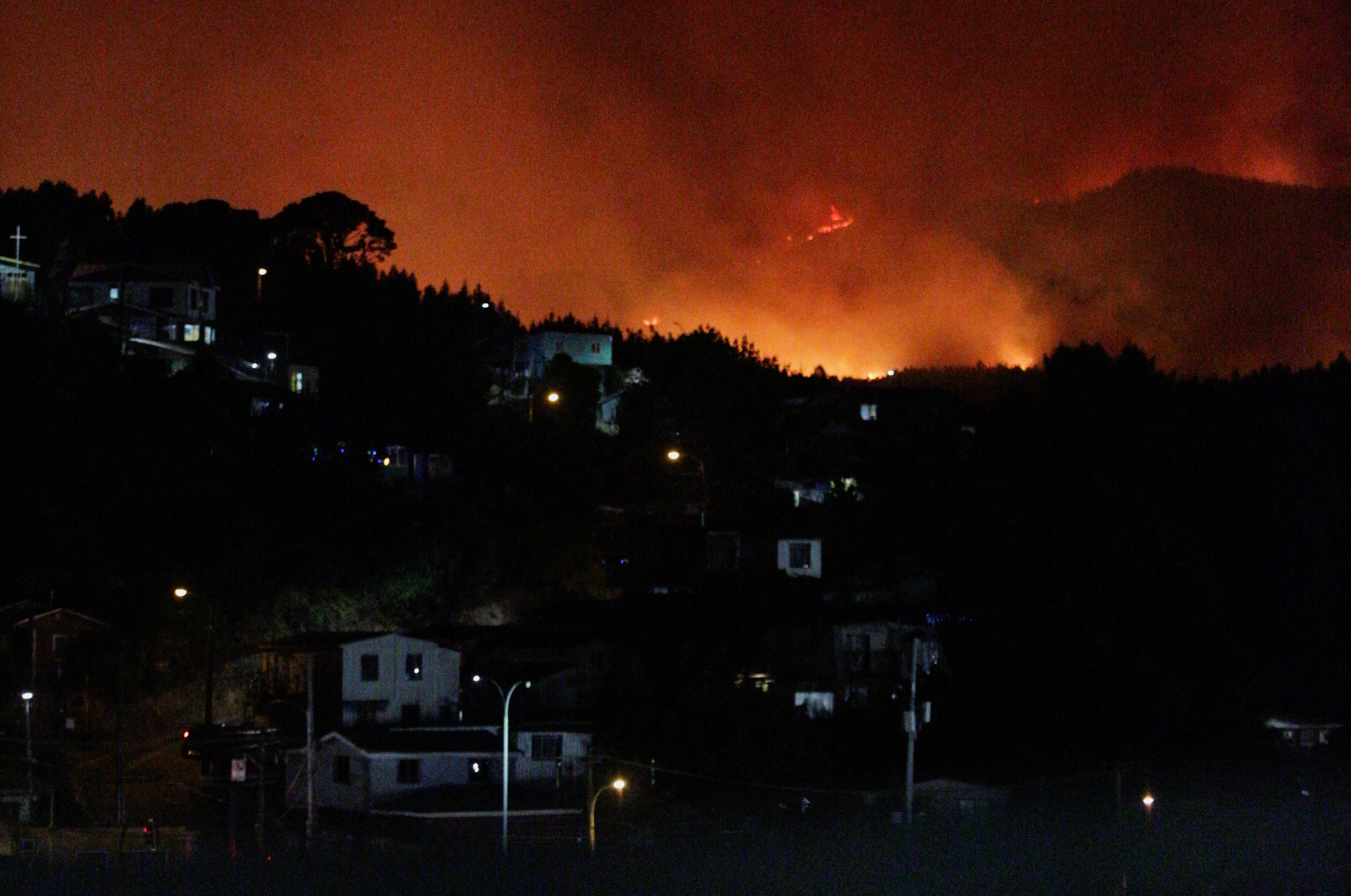 Fire and smoke rise from a forest fire in the Biobio region, where multiple wildfires prompted emergency evacuations, according to local media, in Concepcion, Chile, January 17, 2026. REUTERS/Pablo Hidalgo