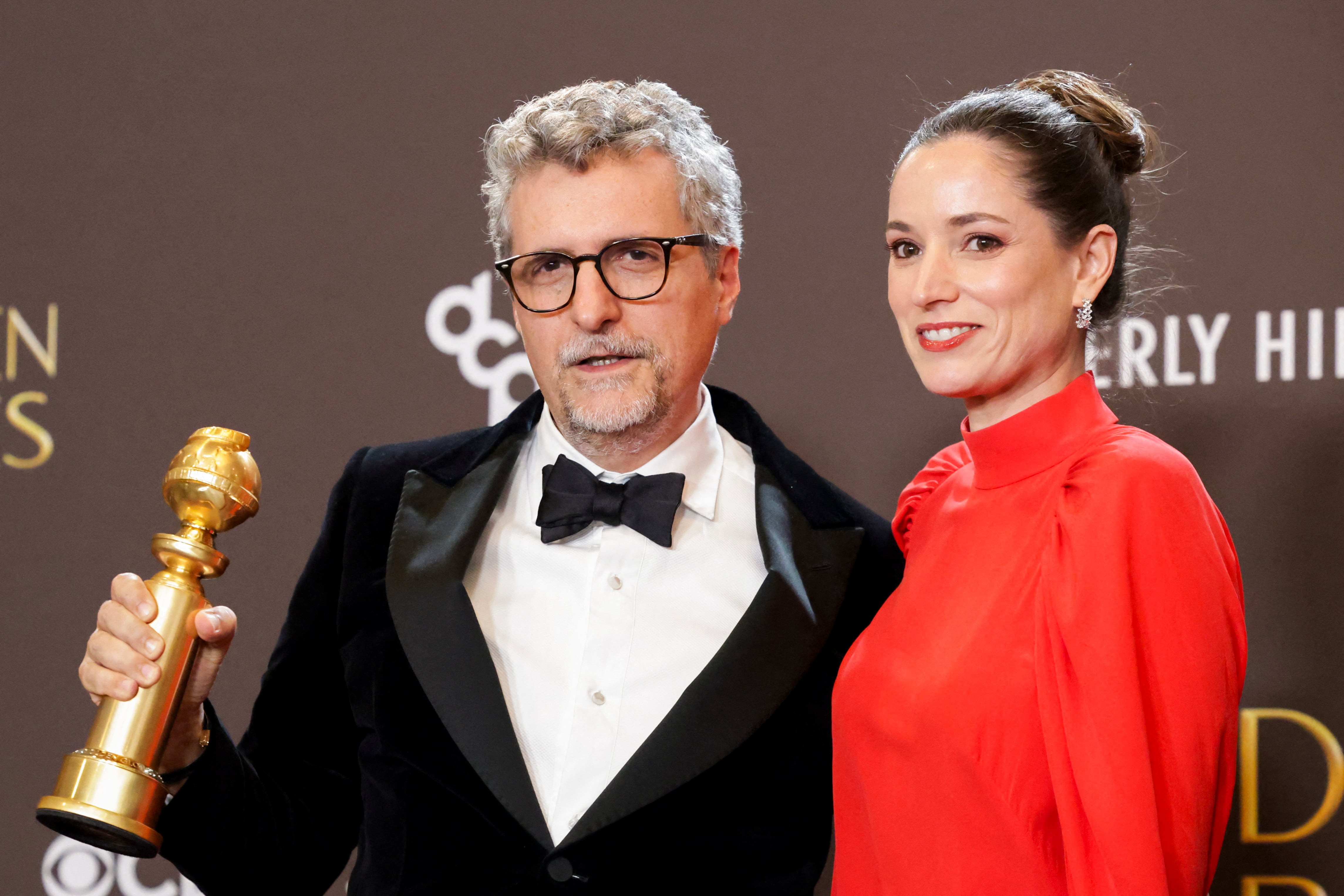 El director Kleber Mendonca Filho y la productora Emilie Lesclaux posan con el Globo de Oro a
