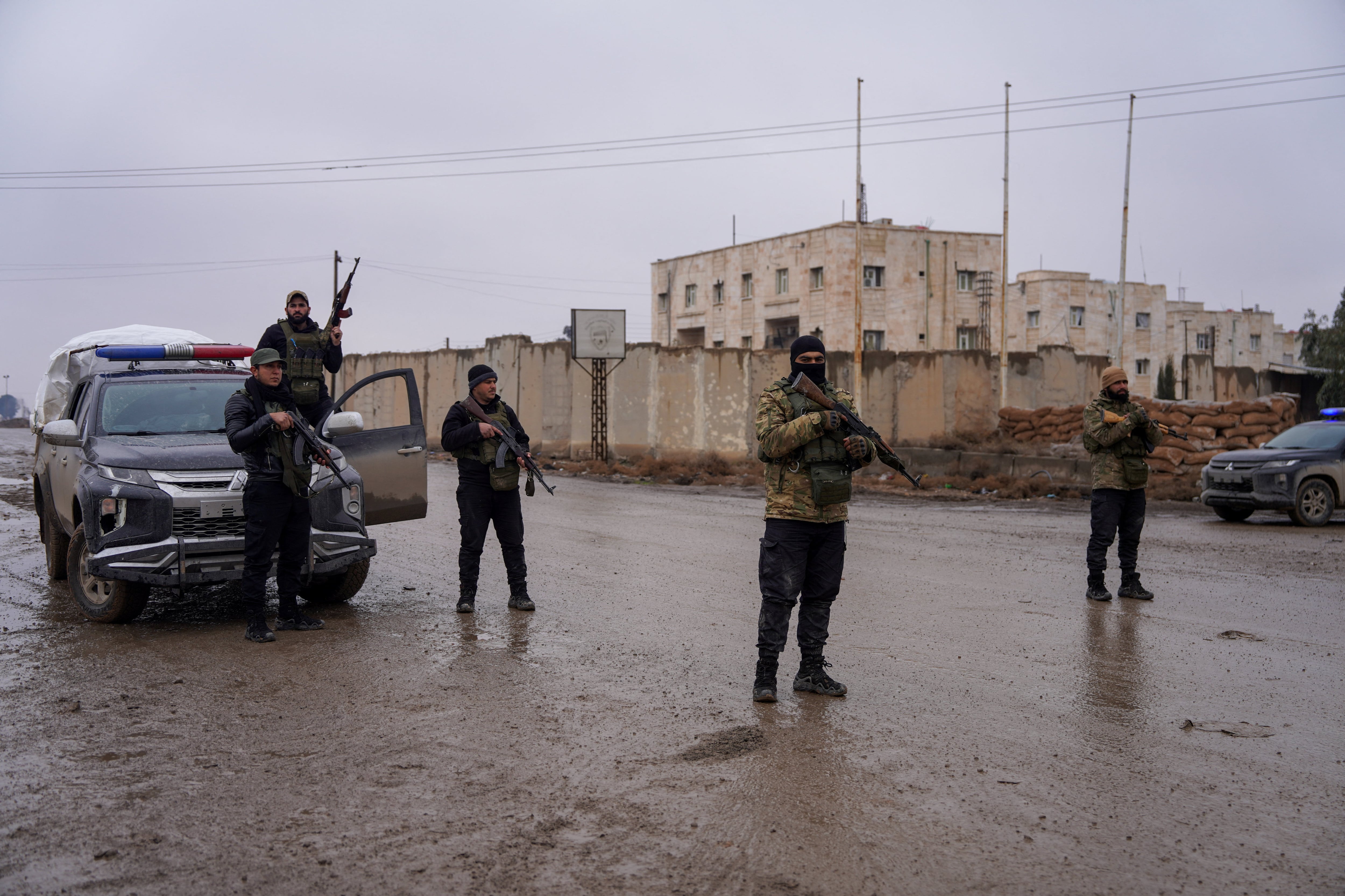 Miembros de las fuerzas de seguridad sirias hacen guardia afuera de la prisión de al-Aqtan, donde se encuentran detenidos algunos miembros del Estado Islámico, en Raqqa, Siria, el 23 de enero de 2026. REUTERS/Karam al-Masri