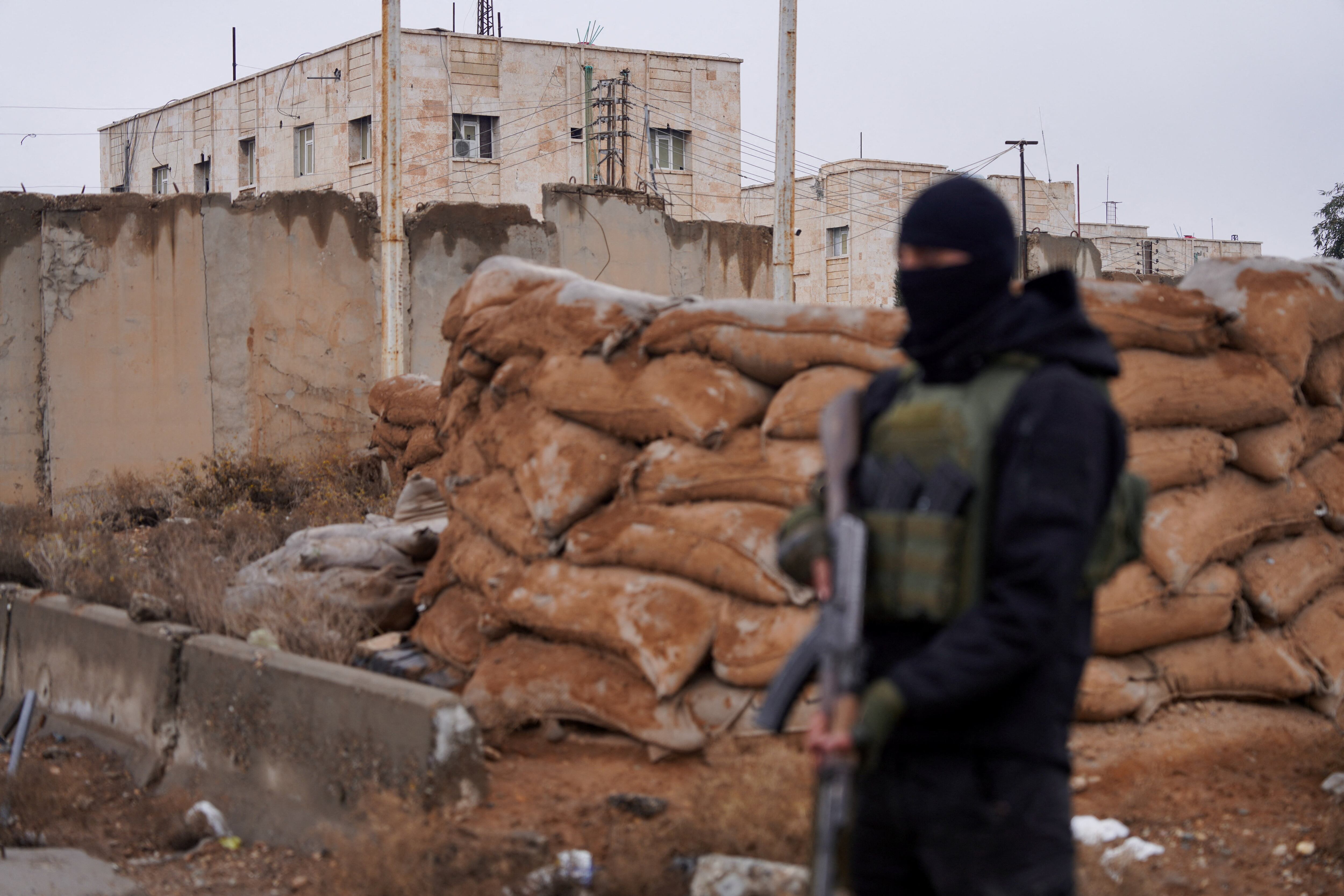 Un miembro de las fuerzas de seguridad sirias hace guardia afuera de la prisión de al-Aqtan, donde se encuentran detenidos algunos miembros del Estado Islámico, en Raqqa, Siria, el 23 de enero de 2026. REUTERS/Karam al-Masri