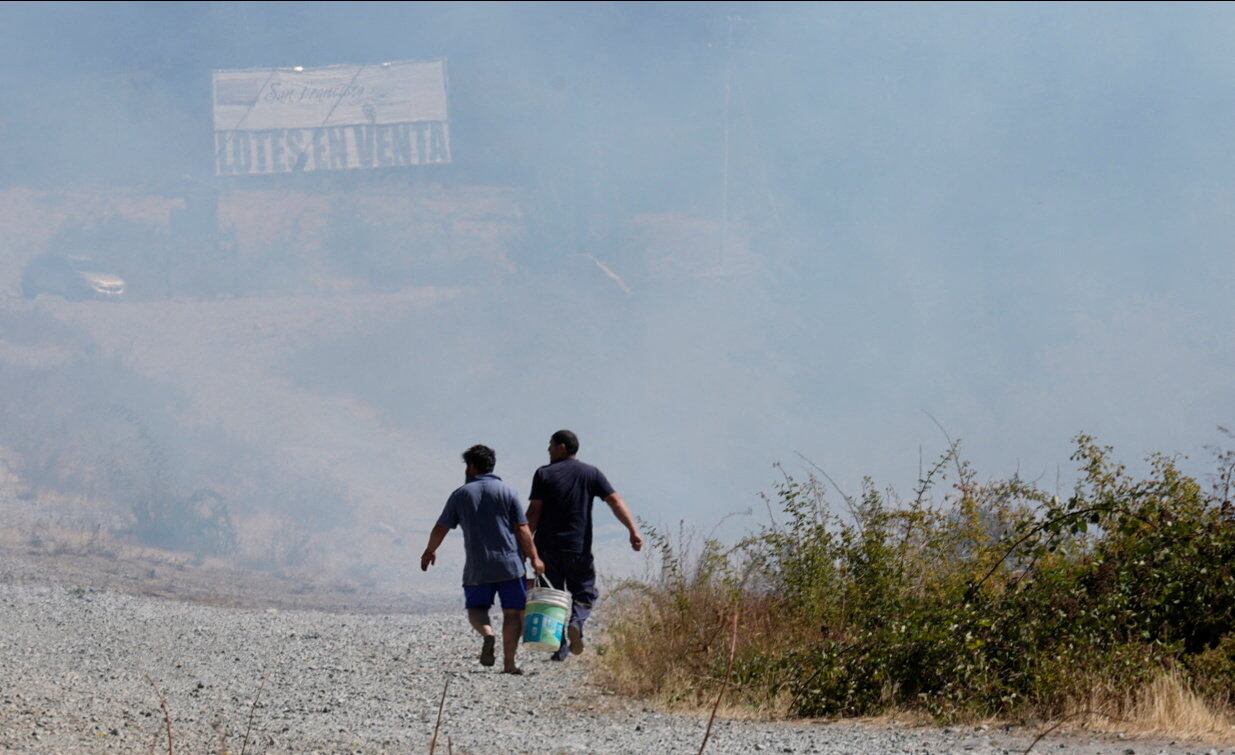 Vecinos cargan baldes con agua mientras avanzan los incendios cerca de Cholila, en la provincia de Chubut (REUTERS/Gonzalo Keogan)
