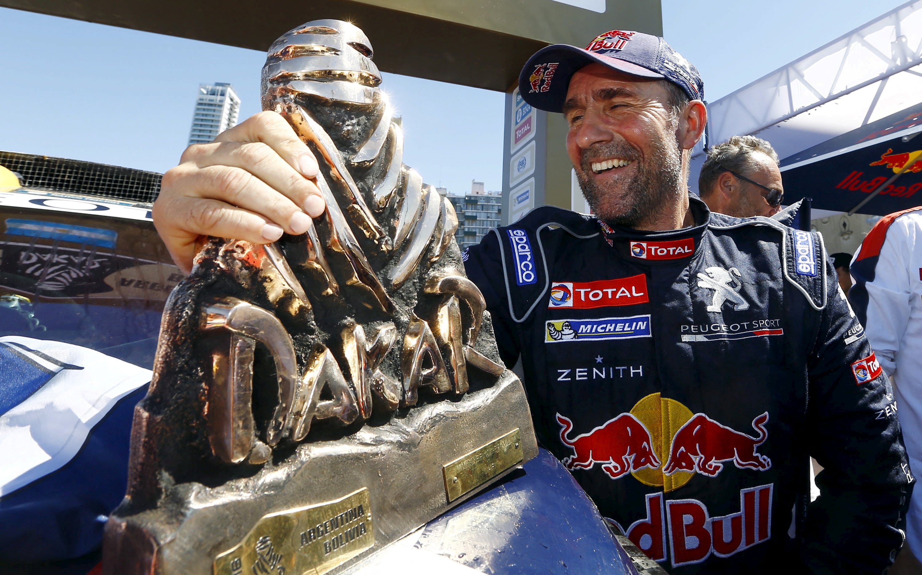 Stephane Peterhansel celebrando su triunfo en 2016, en la edición que terminó en Rosario. Sonríe junto al mítico Touareg, el trofeo del Rally Dakar (REUTERS/Enrique Marcarian/File Photo)