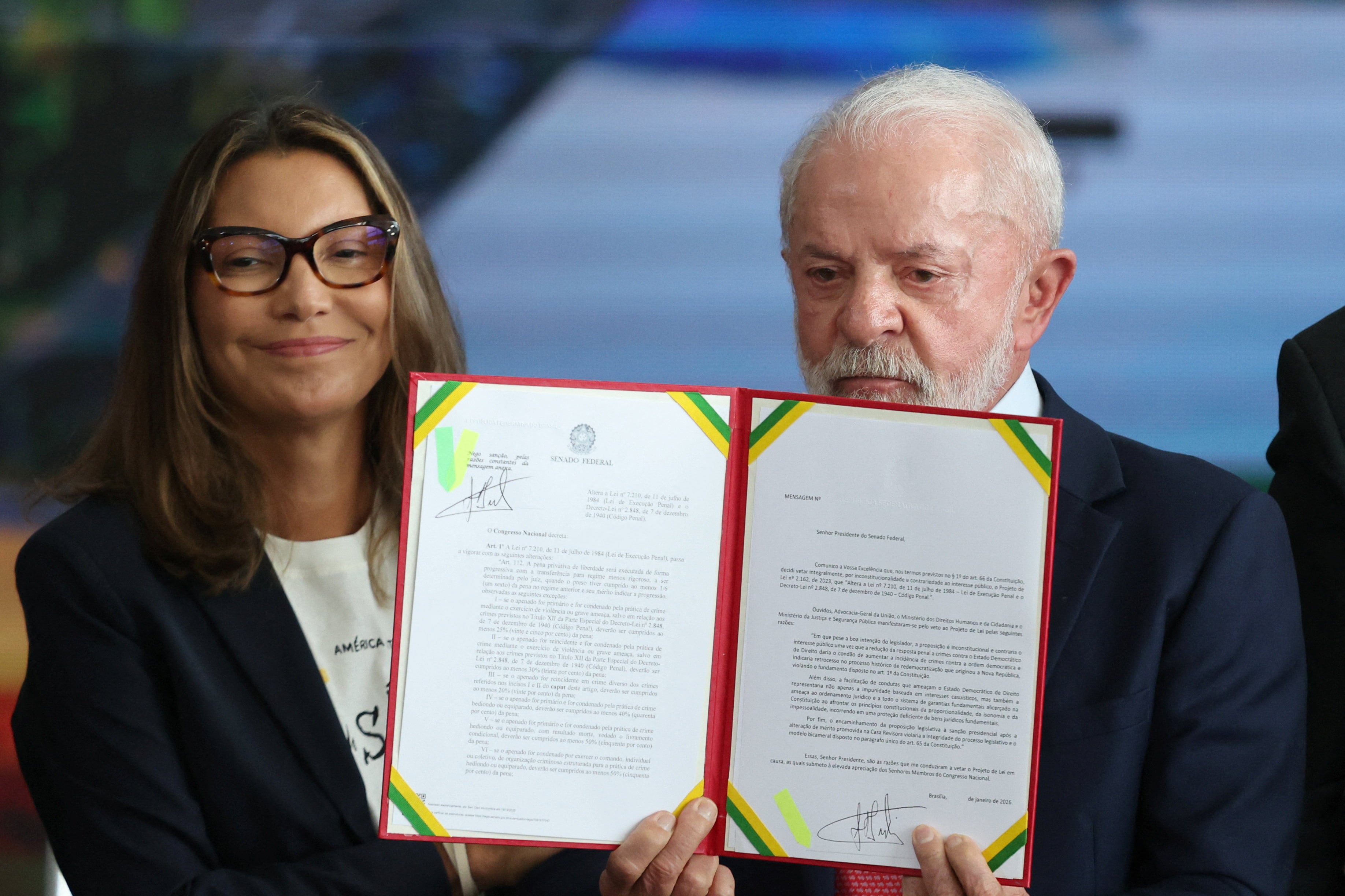 Lula da Silva sostiene un veto firmado a un proyecto de ley que reduce la condena de 27 años de prisión del ex presidente Jair Bolsonaro, mientras está con su esposa Rosangela