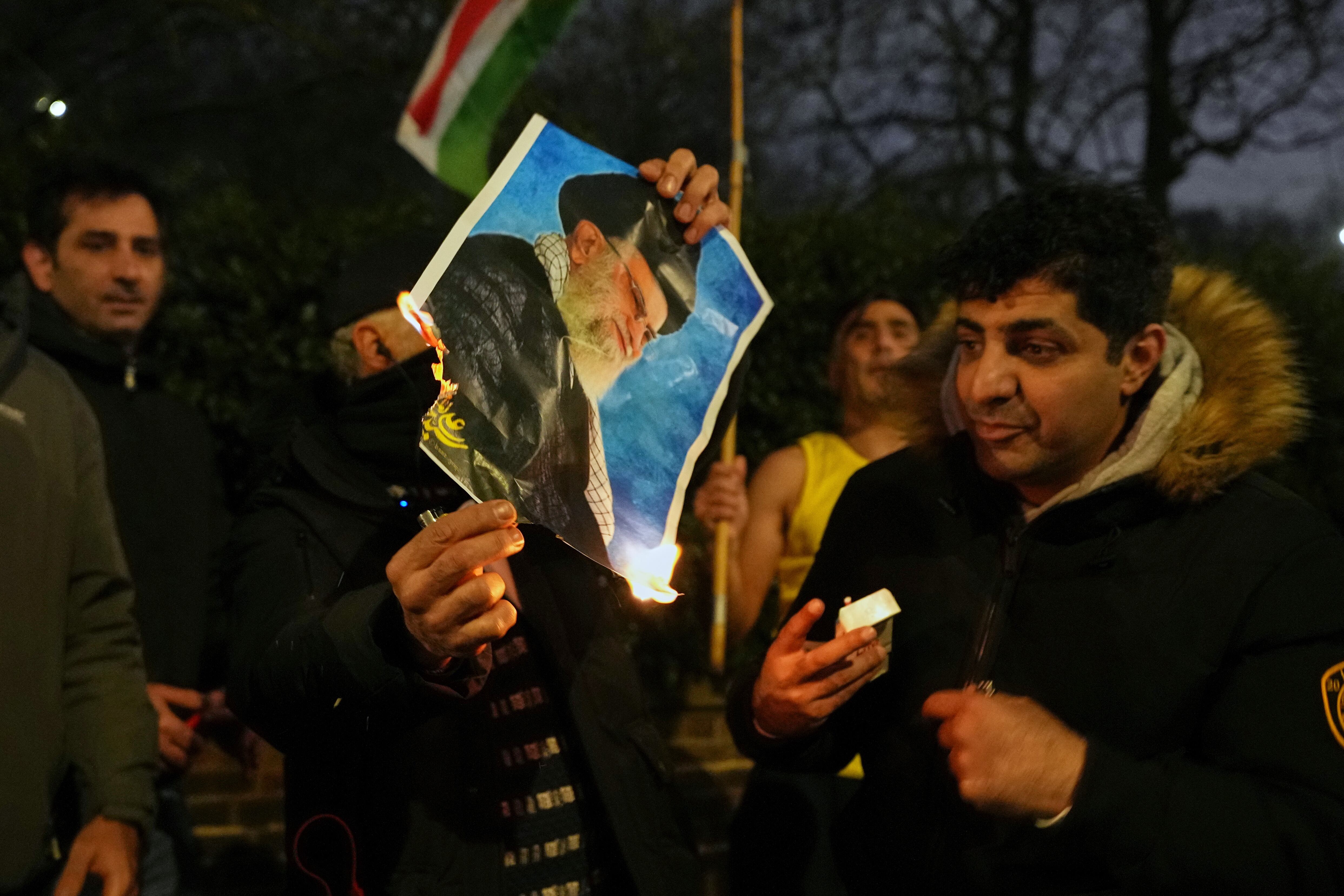Manifestantes queman una foto del ayatolá Ali Khamenei frente a la embajada de Irán en Londres, el lunes 12 de enero de 2026. (Foto AP/Alastair Grant)