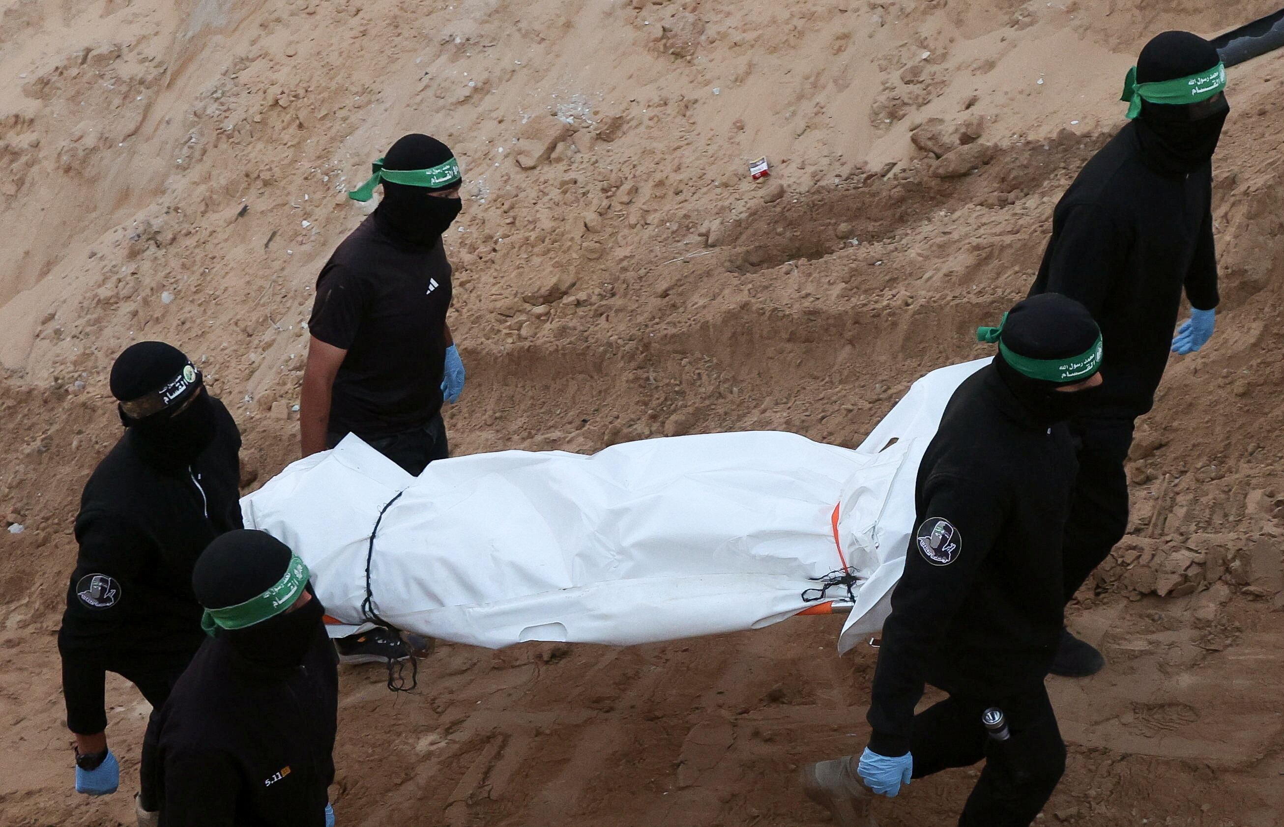 Militantes de Hamás portan un cadáver durante la búsqueda de rehenes fallecidos, en medio de un alto el fuego entre Israel y Hamas, en Khan Younis, sur de la Franja de Gaza. 28 de octubre de 2025 (REUTERS/Ramadan Abed)