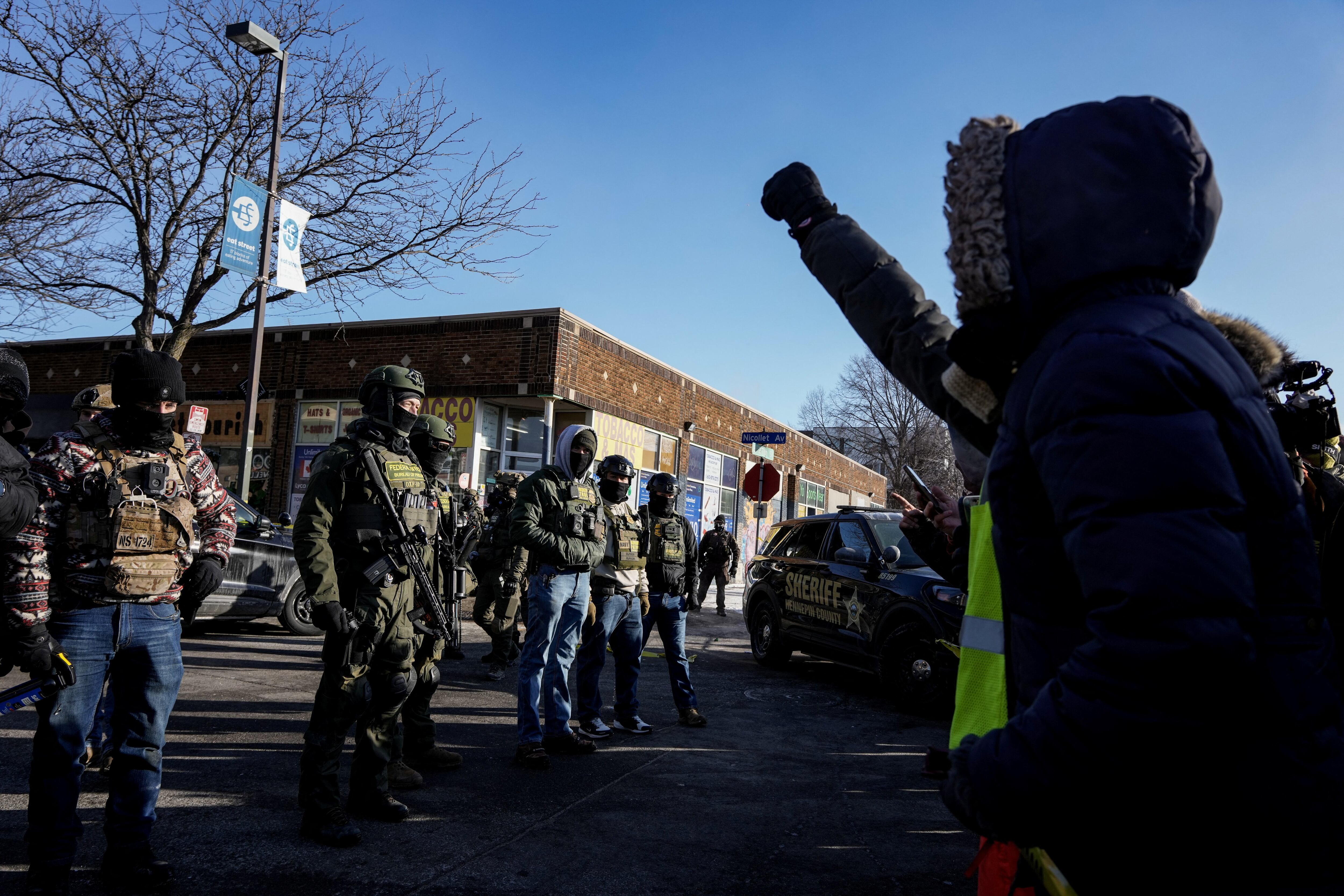 Una persona hace un gesto hacia los agentes federales en la escena de un tiroteo que involucra a agentes federales de inmigración en Mineápolis, Minnesota, EEUU. 24 de enero de 2026. REUTERS/Tim Evans