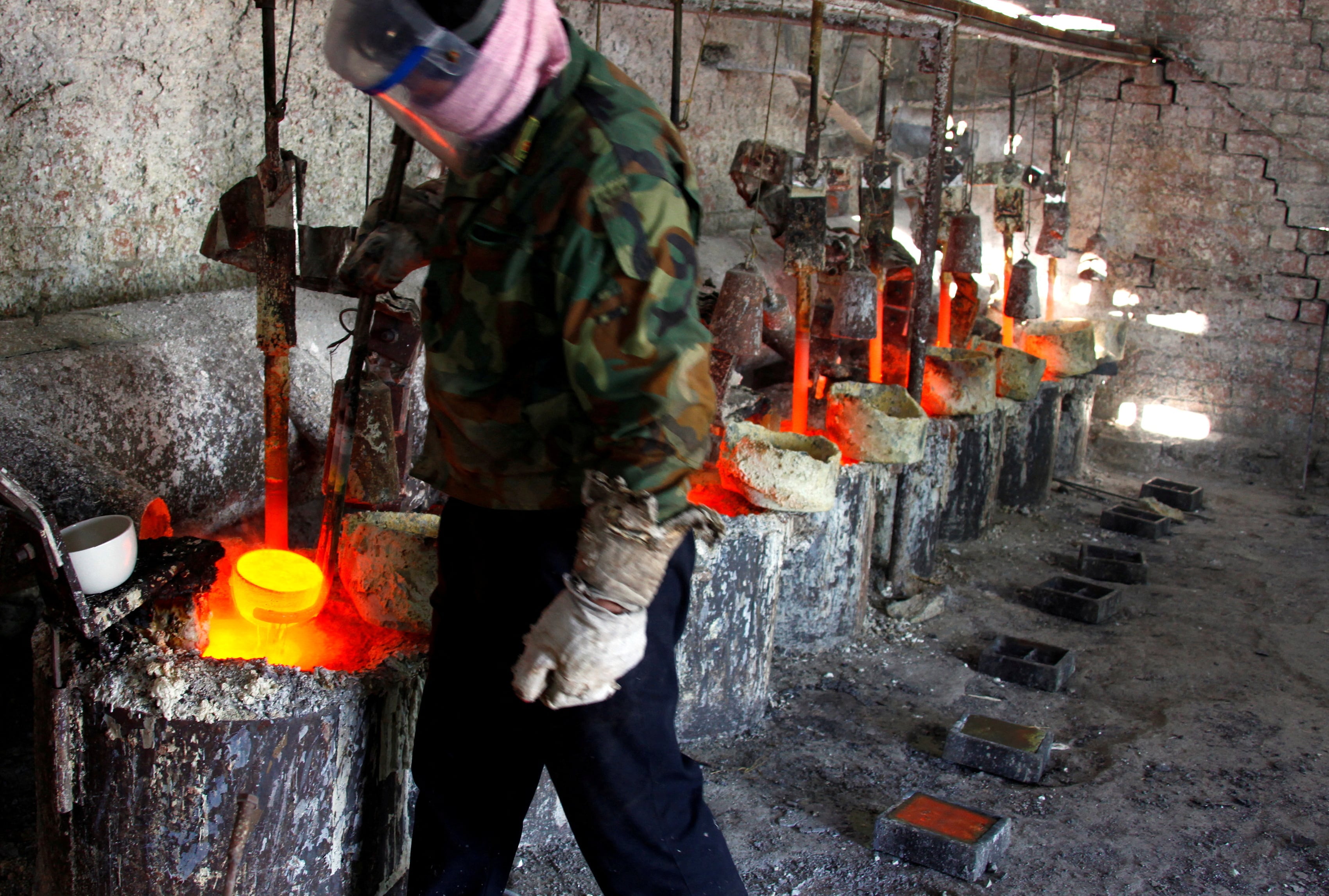 Un trabajador del taller de fundición de la Compañía Jinyuan se prepara para verter lantano, una tierra rara, en un molde cerca de la ciudad de Damao, en la Región Autónoma de Mongolia Interior, China. REUTERS/David Gray