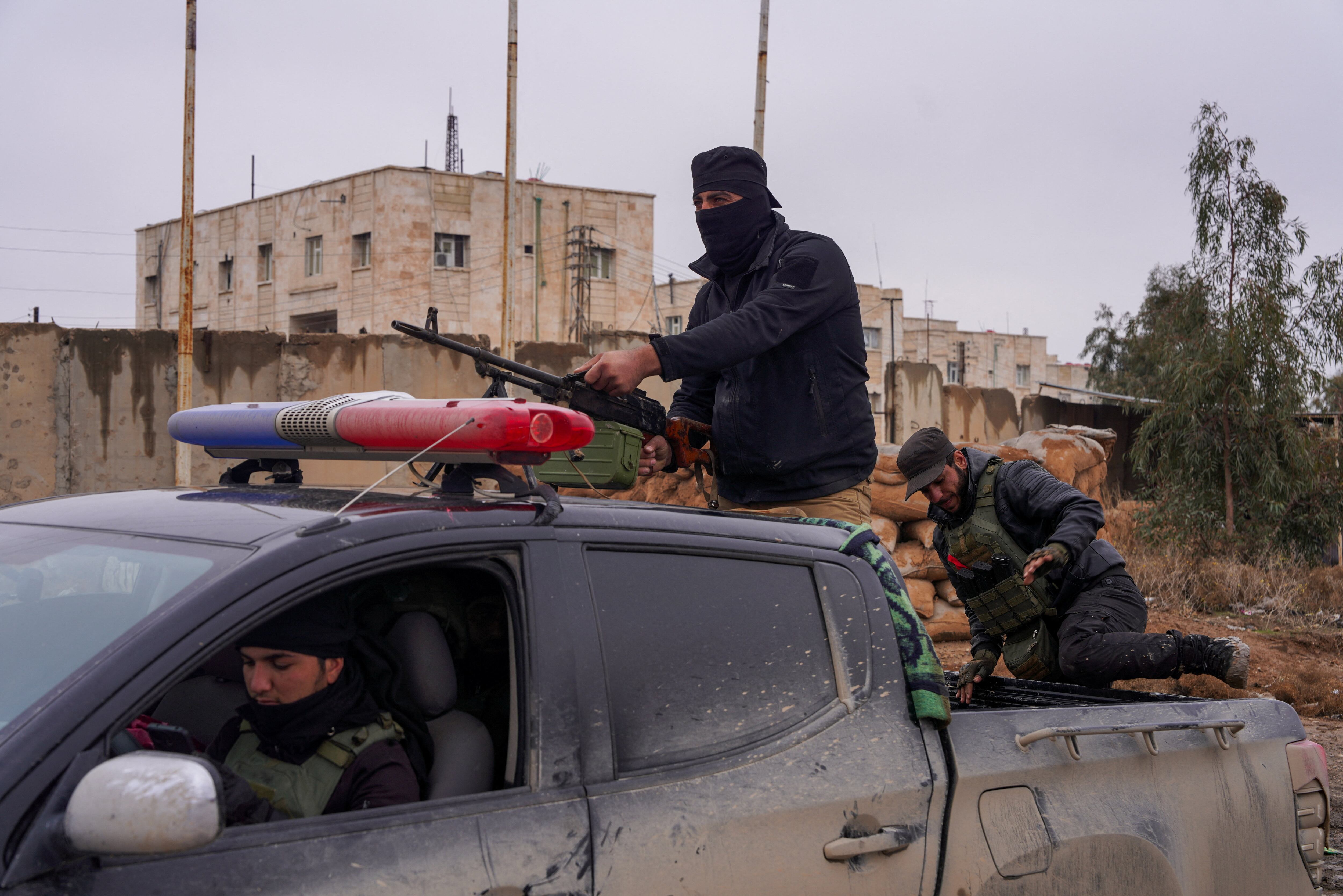 Un miembro de las fuerzas de seguridad sirias custodia la prisión de al-Aqtan en Raqqa, donde permanecen detenidos miembros del Estado Islámico, enero de 2026. Durante el repliegue de las FDS se reportó el colapso de perímetros de seguridad y la fuga de al menos 1,500 prisioneros yihadistas. (REUTERS/Karam al-Masri)