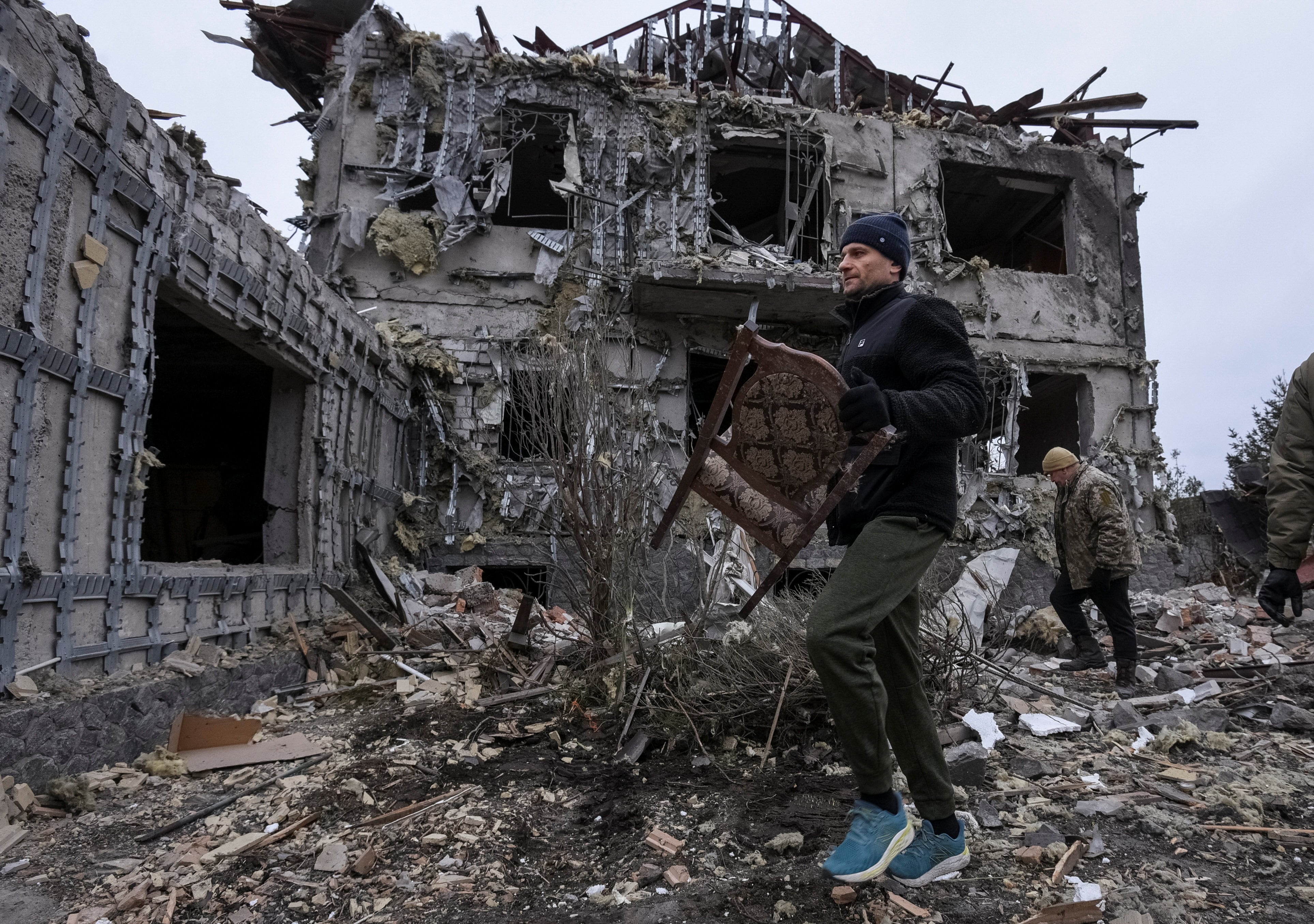 Un residente lleva una silla recogida de un edificio alcanzado durante el ataque ruso con misiles y drones, en medio del ataque de Rusia a Ucrania, en la región de Dnipropetrovsk (REUTERS/Mykola Synelnykov)