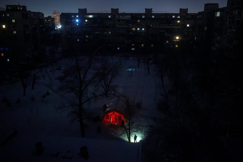 Una persona se ilumina con una linterna en una zona residencial que se quedó sin calefacción en la capital ucraniana. (REUTERS/Thomas Peter)