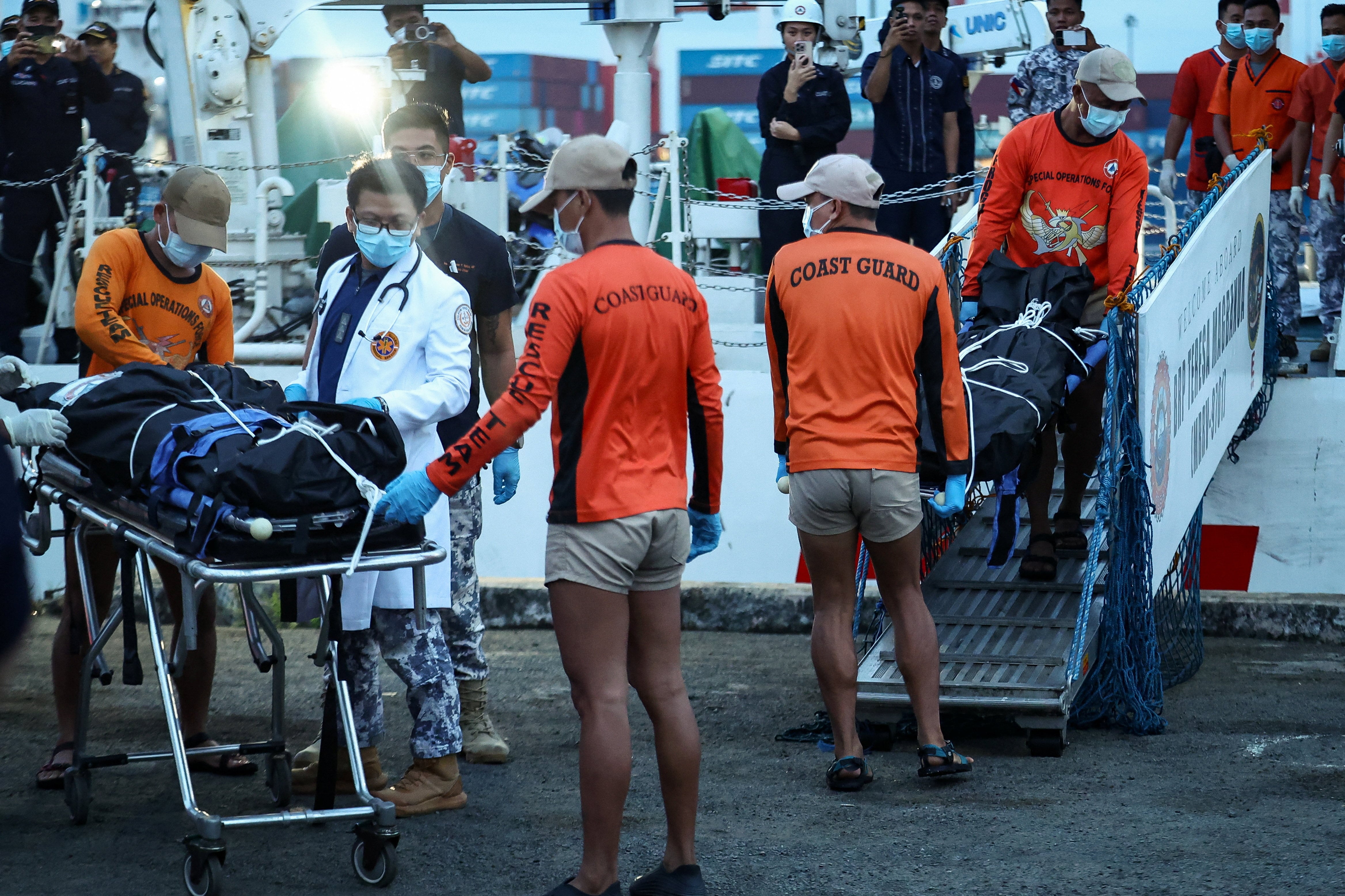 Personal de la Guardia Costera de Filipinas transporta bolsas con los restos mortales de los tripulantes fallecidos en el hundimiento del buque de carga M/V Devon Bay, en el puerto de Manila, Filipinas (REUTERS/Eloisa López)