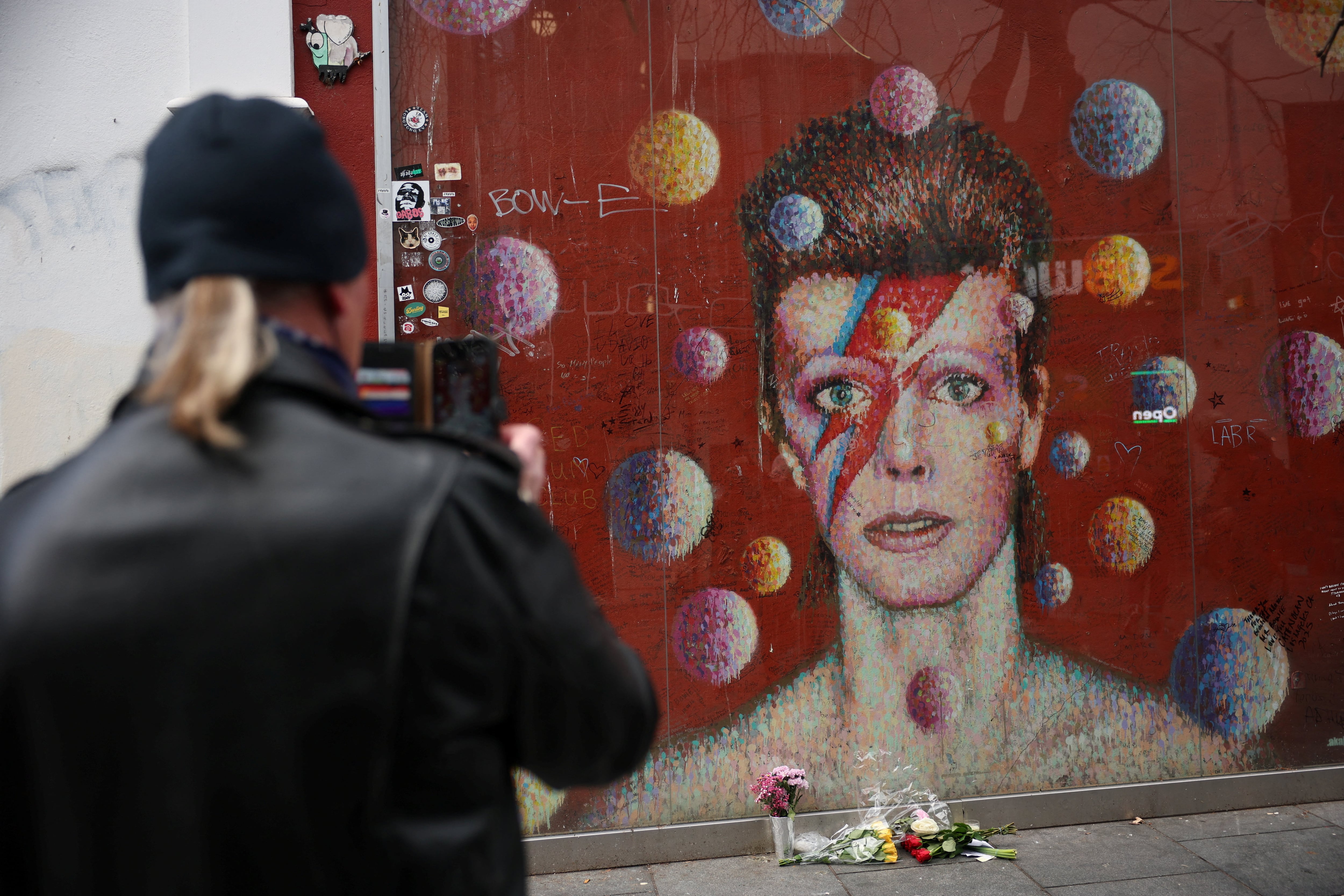 Un hombre fotografía un mural dedicado a David Bowie con motivo del décimo aniversario de su muerte, en Brixton, Londres, Reino Unido, el 10 de enero de 2026. (REUTERS/Isabel Infantes)