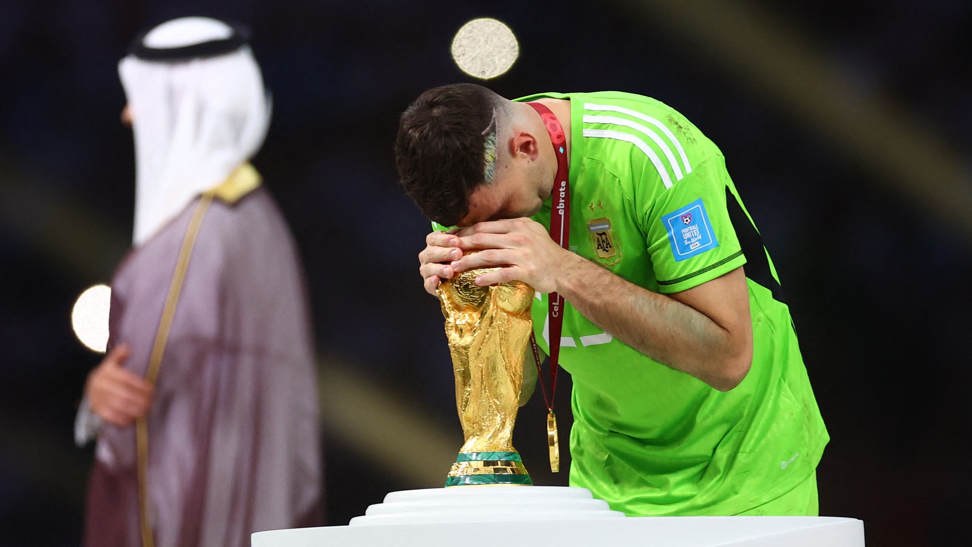 El deseo de toda una vida: Dibu Martínez se inclina sobre la Copa del Mundo después de imponerse en la final (Crédito: Reuters/Carl Recine)