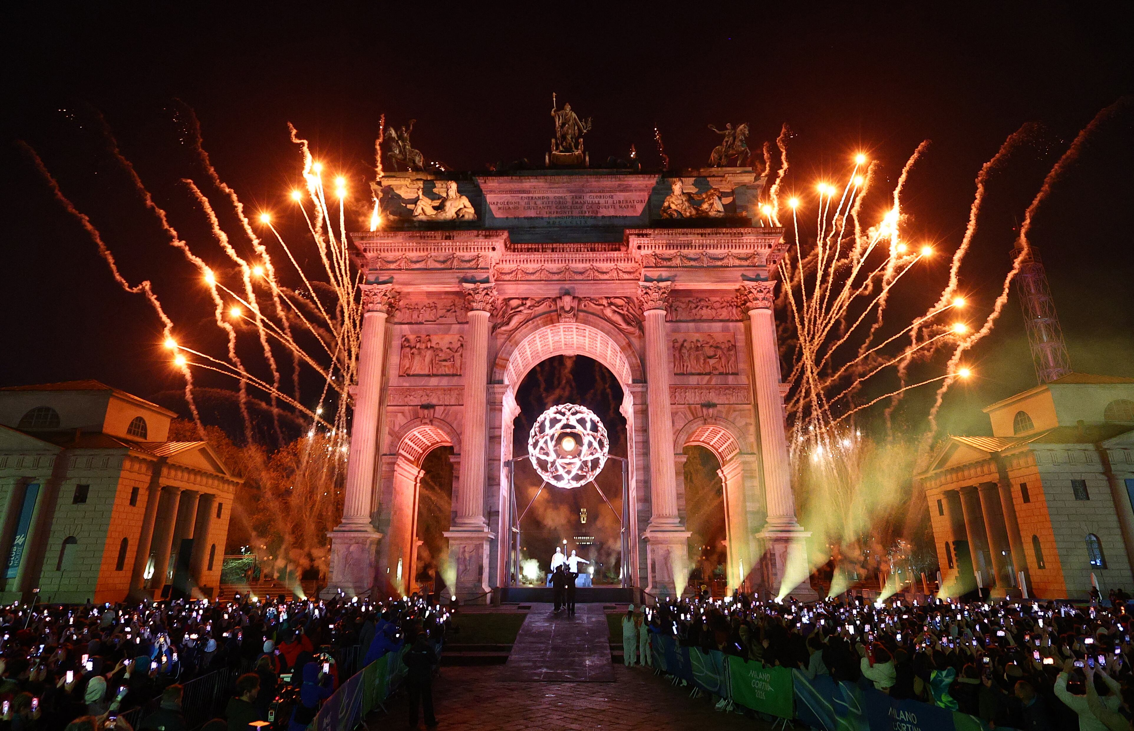 Vista general de los fuegos artificiales mientras Alberto Tomba y Deborah Compagnoni encienden el pebetero olímpico bajo el Arco della Pace en Milán