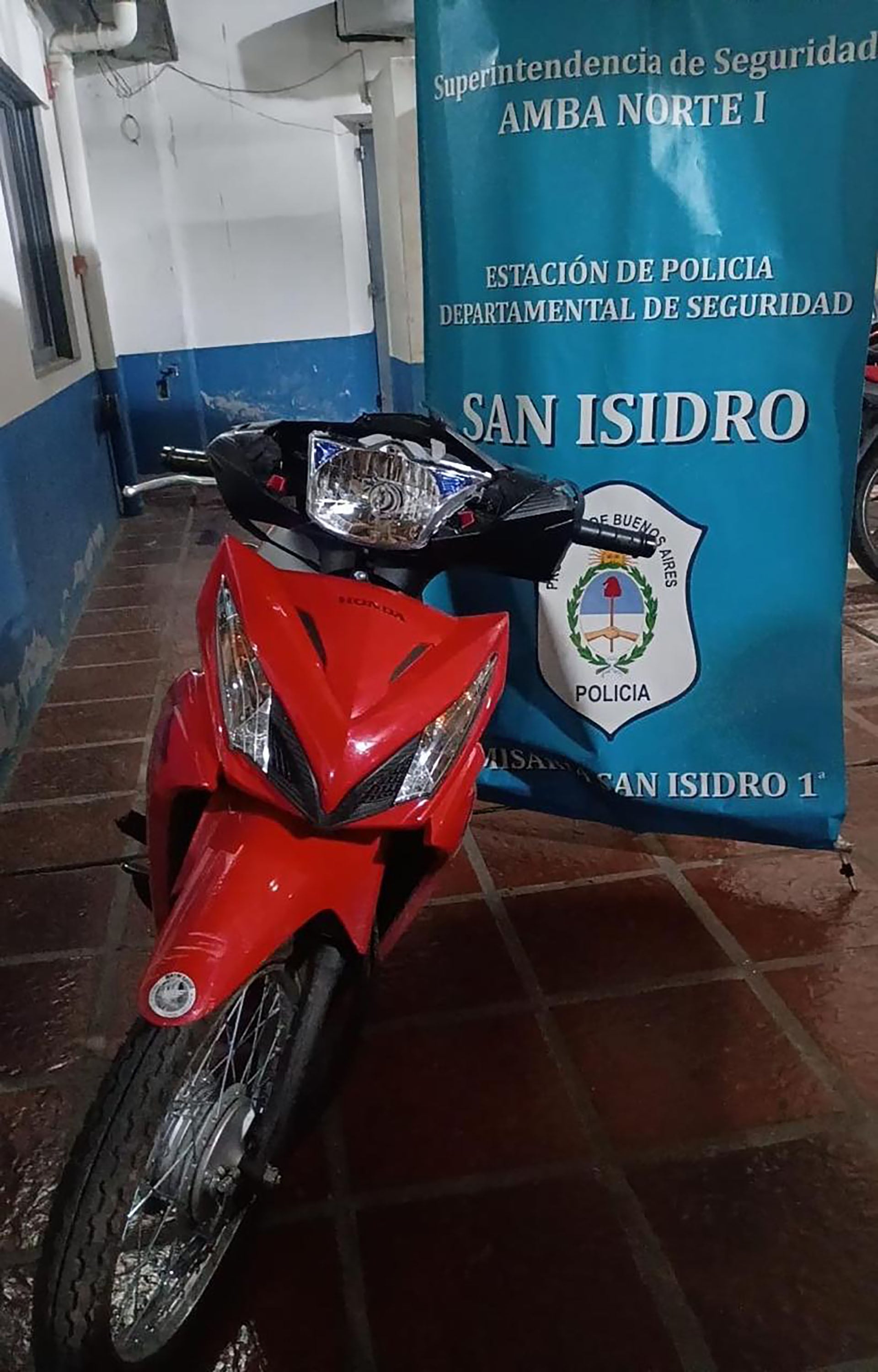 Una moto Honda roja fue incautada en la Estación de Policía de San Isidro, vinculada a la detención de dos de los tres miembros de la