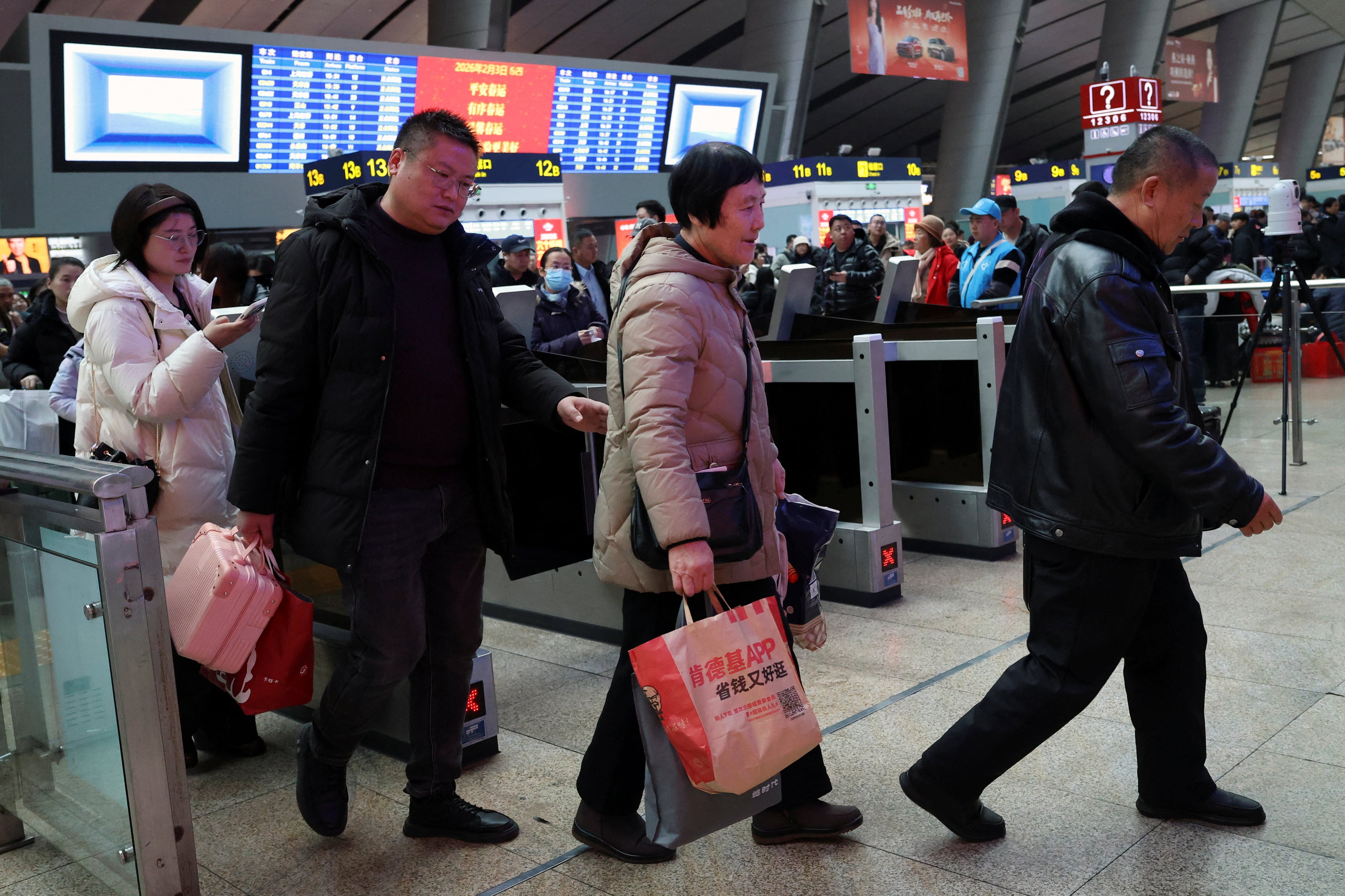 Los viajeros pasan por una puerta de embarque para abordar su tren en la Estación Sur de Trenes de Beijing. REUTERS/Florence Lo