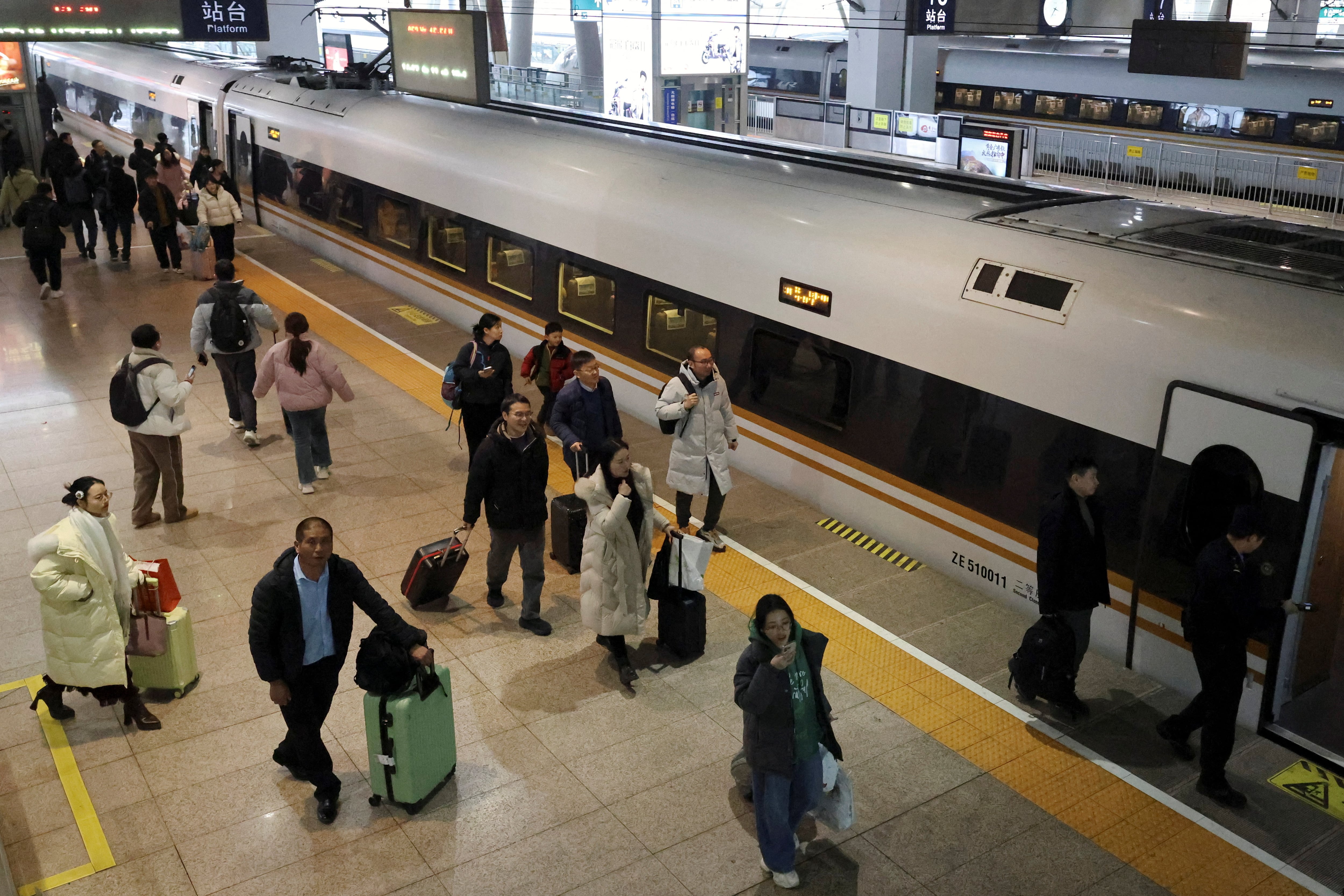 Los viajeros abordan su tren en un andén de la Estación Sur de Trenes de Beijing durante la temporada alta de viajes del Año Nuevo Lunar. REUTERS/Florence Lo