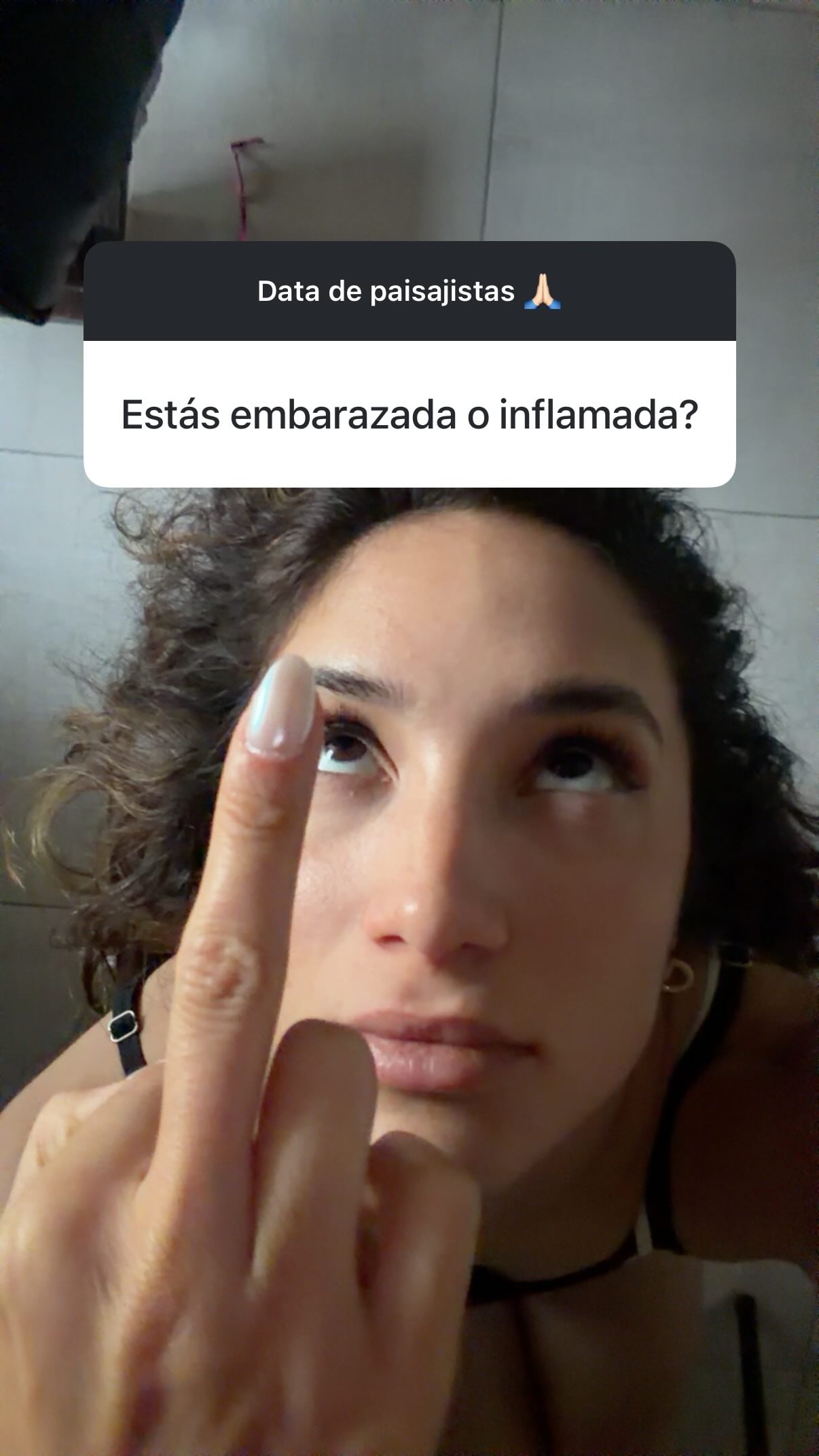 Melody Luz hace un gesto de desaprobación mientras mira hacia arriba, con un texto superpuesto preguntando si está embarazada o inflamada (Instagram)