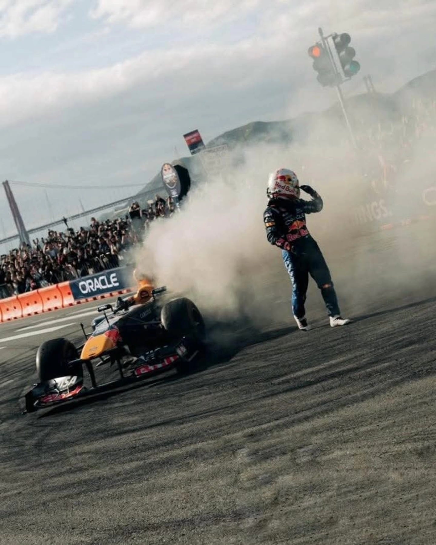 Yuki Tsunoda camina alejándose de su coche de carreras, que emite una densa columna de humo, durante un incidente en la Race of Champions.