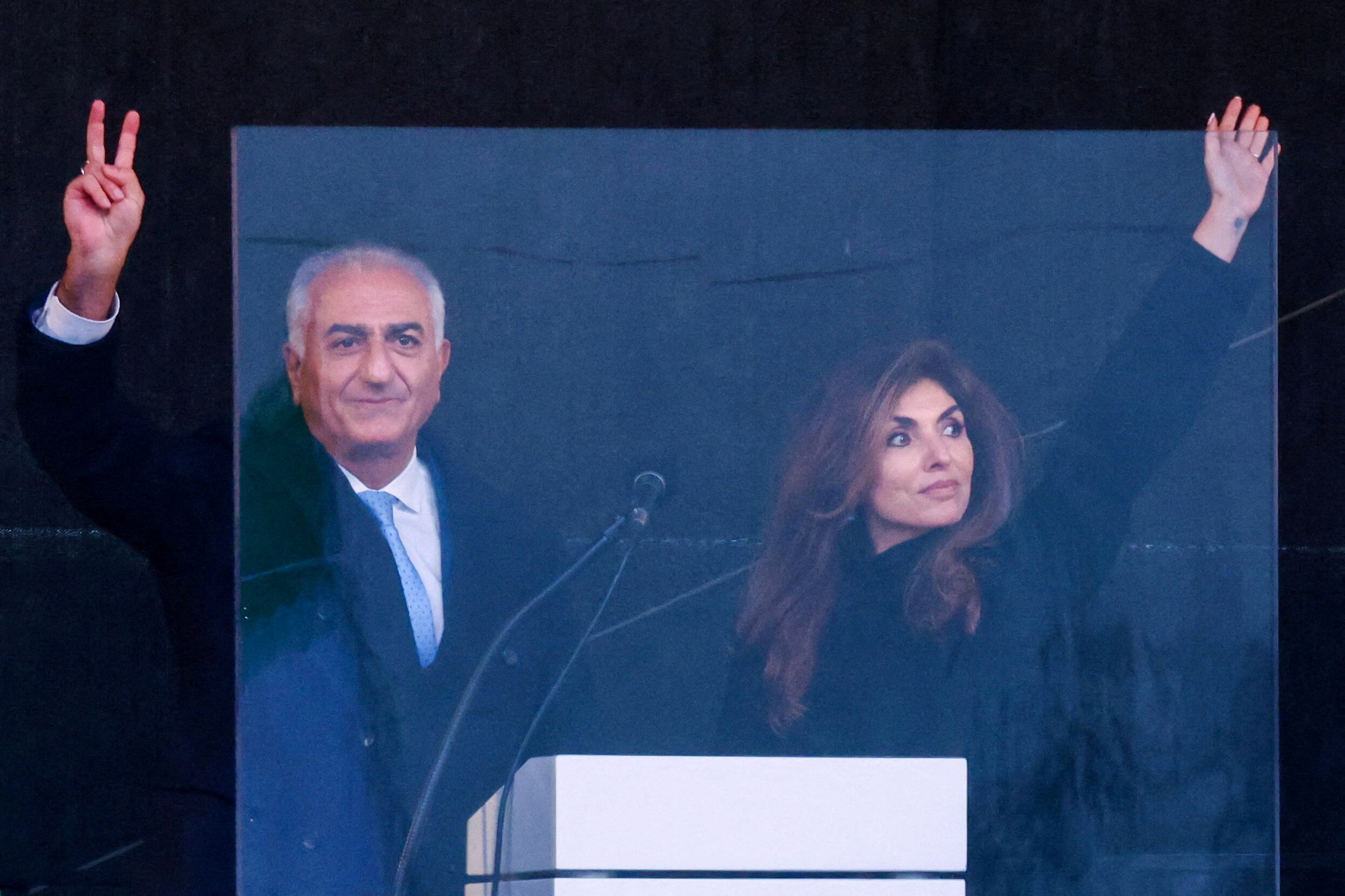Reza Pahlavi, hijo exiliado del último sha de Irán y figura de la oposición iraní, y su esposa Yasmine Pahlavi hacen un gesto desde el escenario mientras asisten a una manifestación organizada bajo el lema 