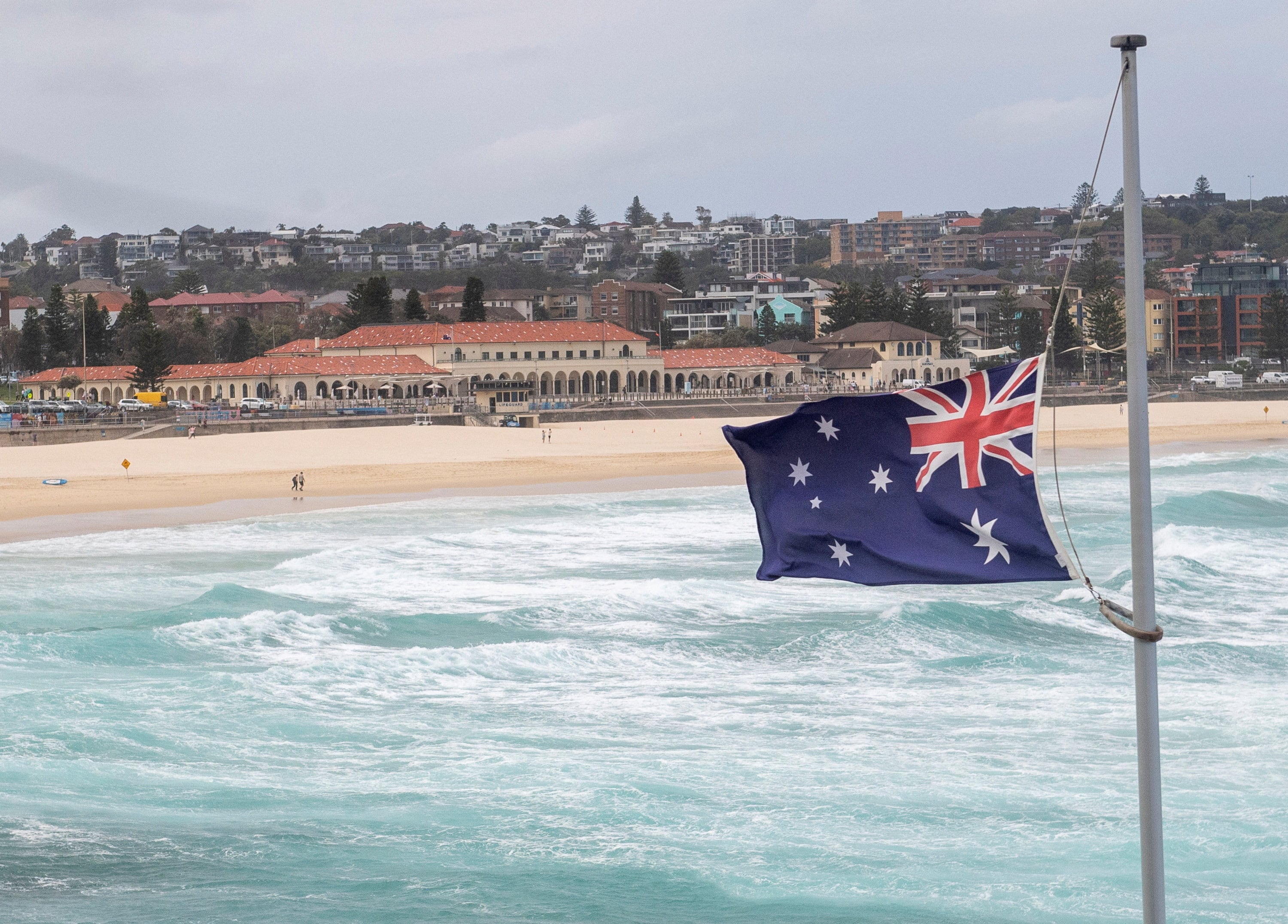La bandera nacional de Australia ondea a media asta en Bondi Beach durante el Día Nacional de Luto por las víctimas del tiroteo masivo de Bondi Beach en Sídney, Australia, el 22 de enero de 2026 (REUTERS/Jeremy Piper)