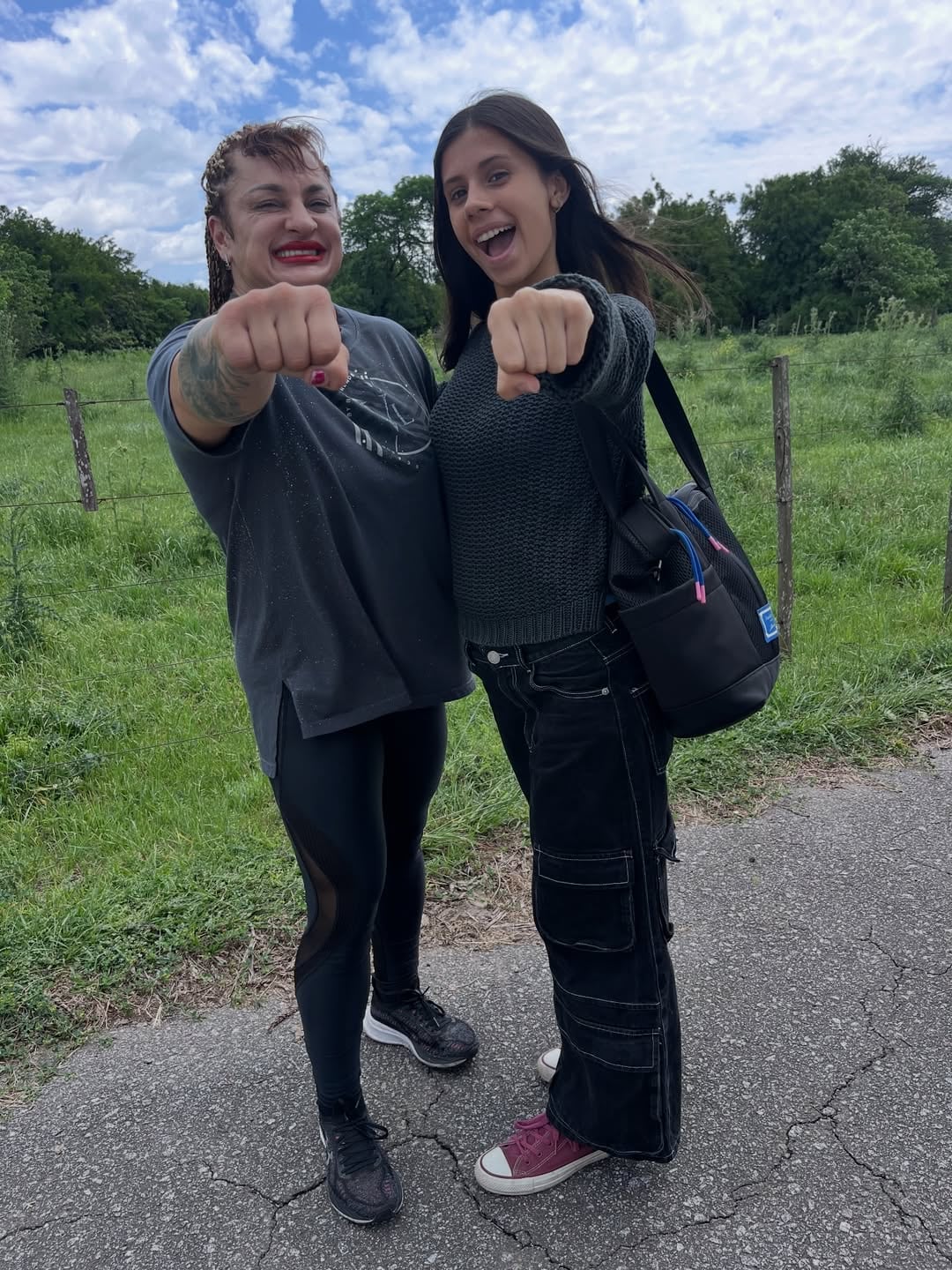 La actriz Deflina Pulen y la reconocida Locomotora Oliveras posan con los puños al frente, mostrando su energía durante una reciente aparición.