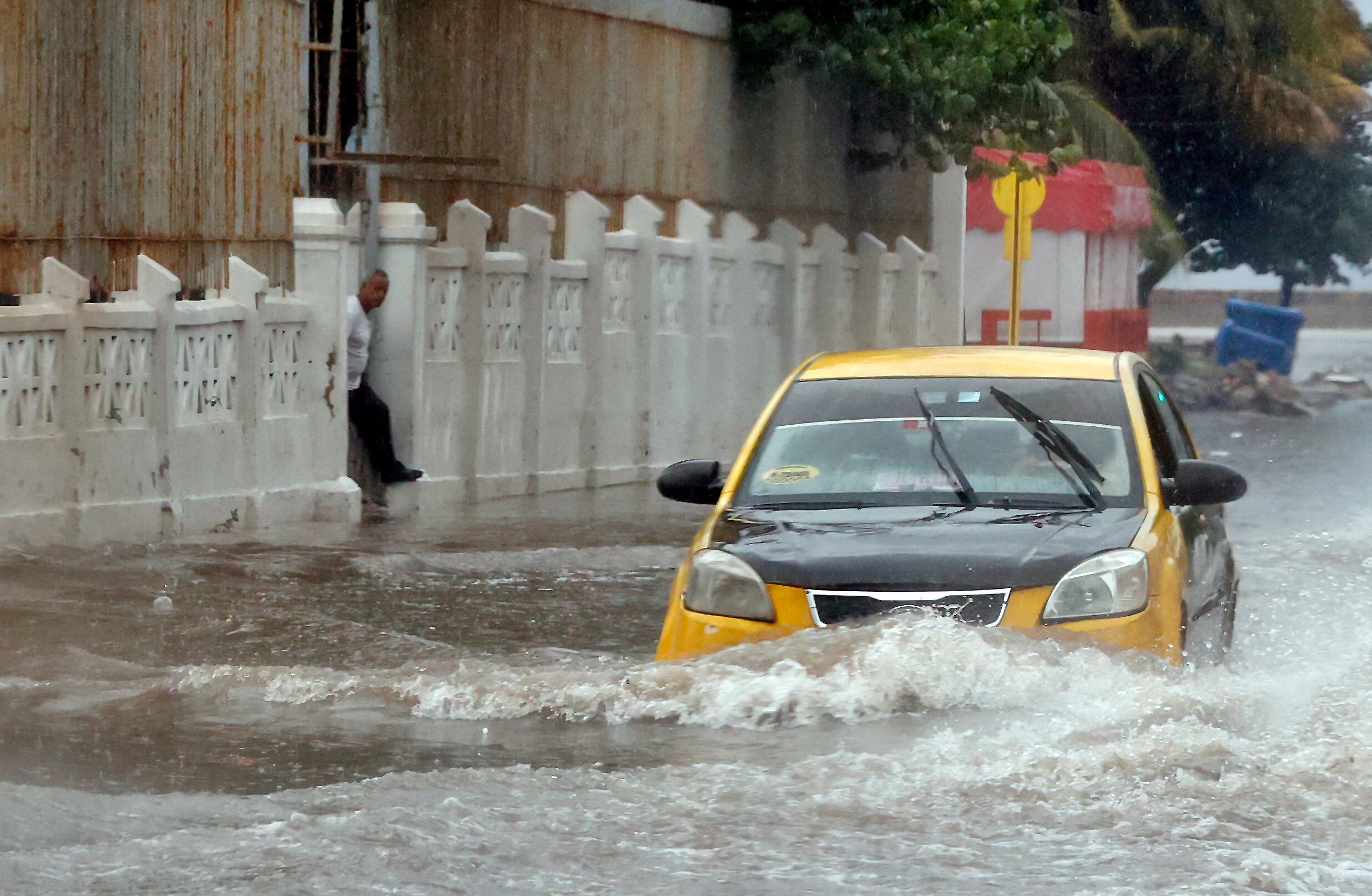 Un automóvil transita por una calle inundada, debido a las lluvias, en La Habana (EFE/Ernesto Mastrascusa) 