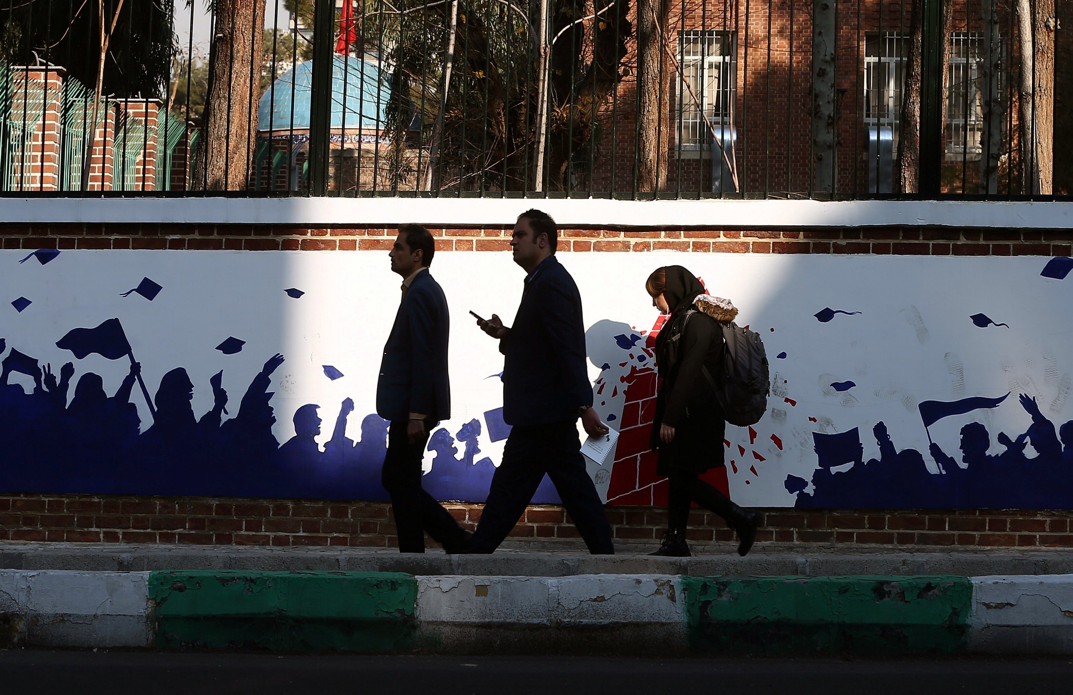 Personas pasan junto a un mural antiestadounidense en el muro de la antigua embajada de Estados Unidos en Teherán, Irán (Nazanin Tabatabaee/WANA/vía REUTERS/Archivo)