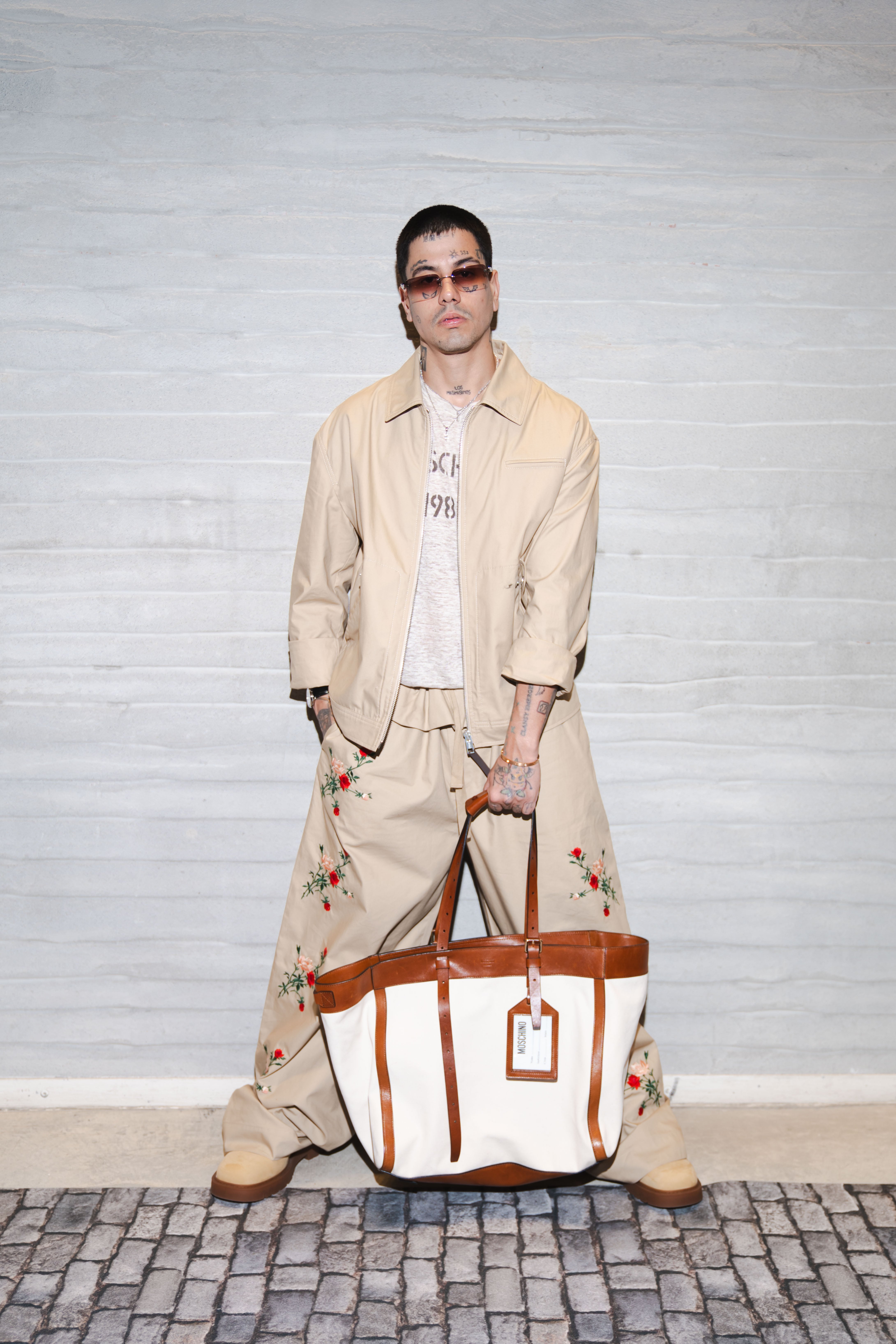 Duki asiste a la Semana de la Moda de Milán luciendo un conjunto casual con bordados florales y un bolso Moschino que complementa su atuendo