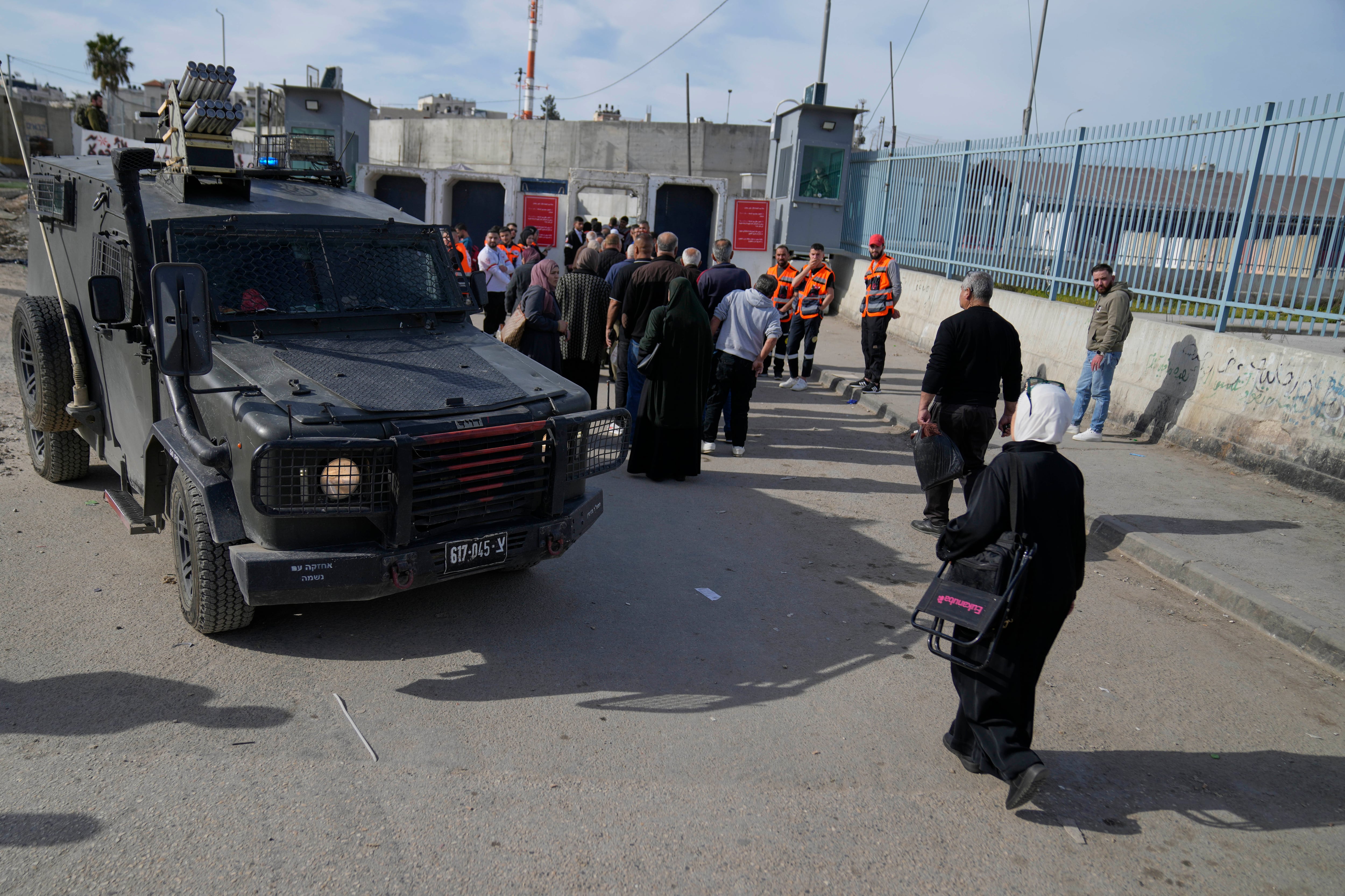 Un grupo de palestinos cruza desde el retén del Ejército israelí en Kalandia, cerca de la ciudad cisjordana de Ramala, hacia Jerusalén, para participar en las oraciones del viernes en la mezquita de Al-Aqsa, durante el mes sagrado musulmán de ramadán, el viernes 14 de marzo de 2025 (AP Foto/Nasser Nasser)