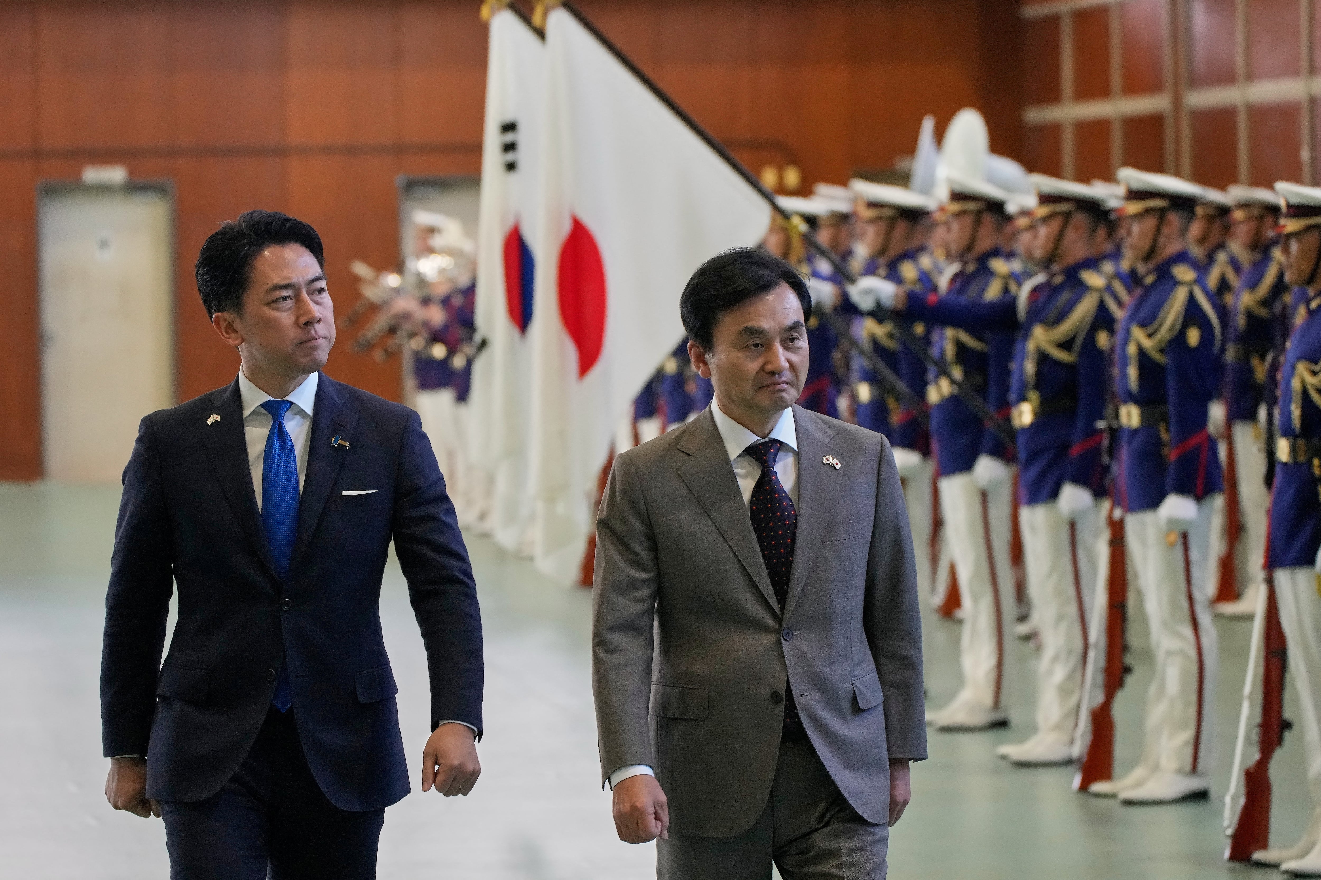 El ministro de Defensa de Japón, Shinjiro Koizumi, y el ministro de Defensa de Corea del Sur, Ahn Gyu-back, pasan revista a las tropas durante una ceremonia en la sede de la Fuerza de Autodefensa Marítima de Japón (Eugene Hoshiko/REUTERS/Archivo)