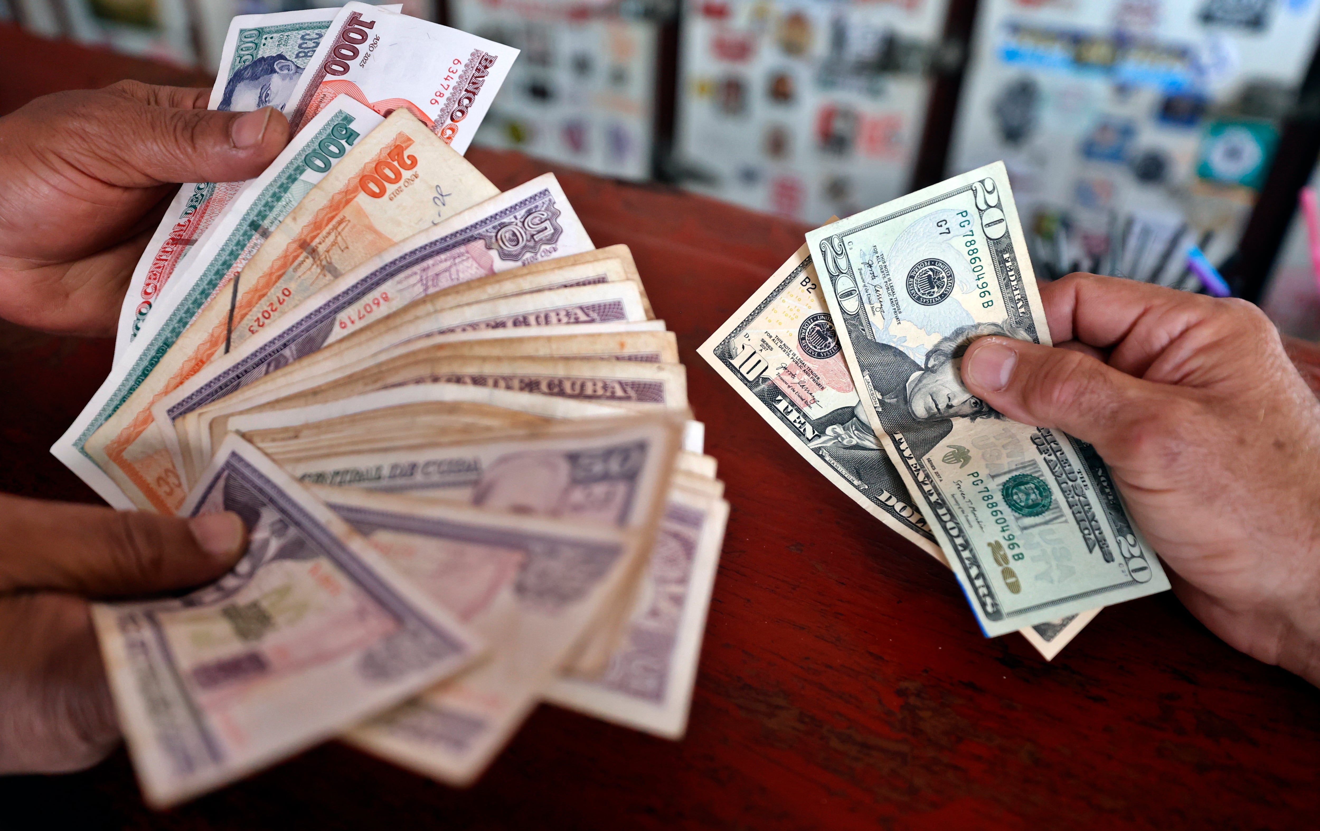 Personas muestran billetes de pesos cubanos y dólares este miércoles, en La Habana (EFE/Ernesto Mastrascusa)