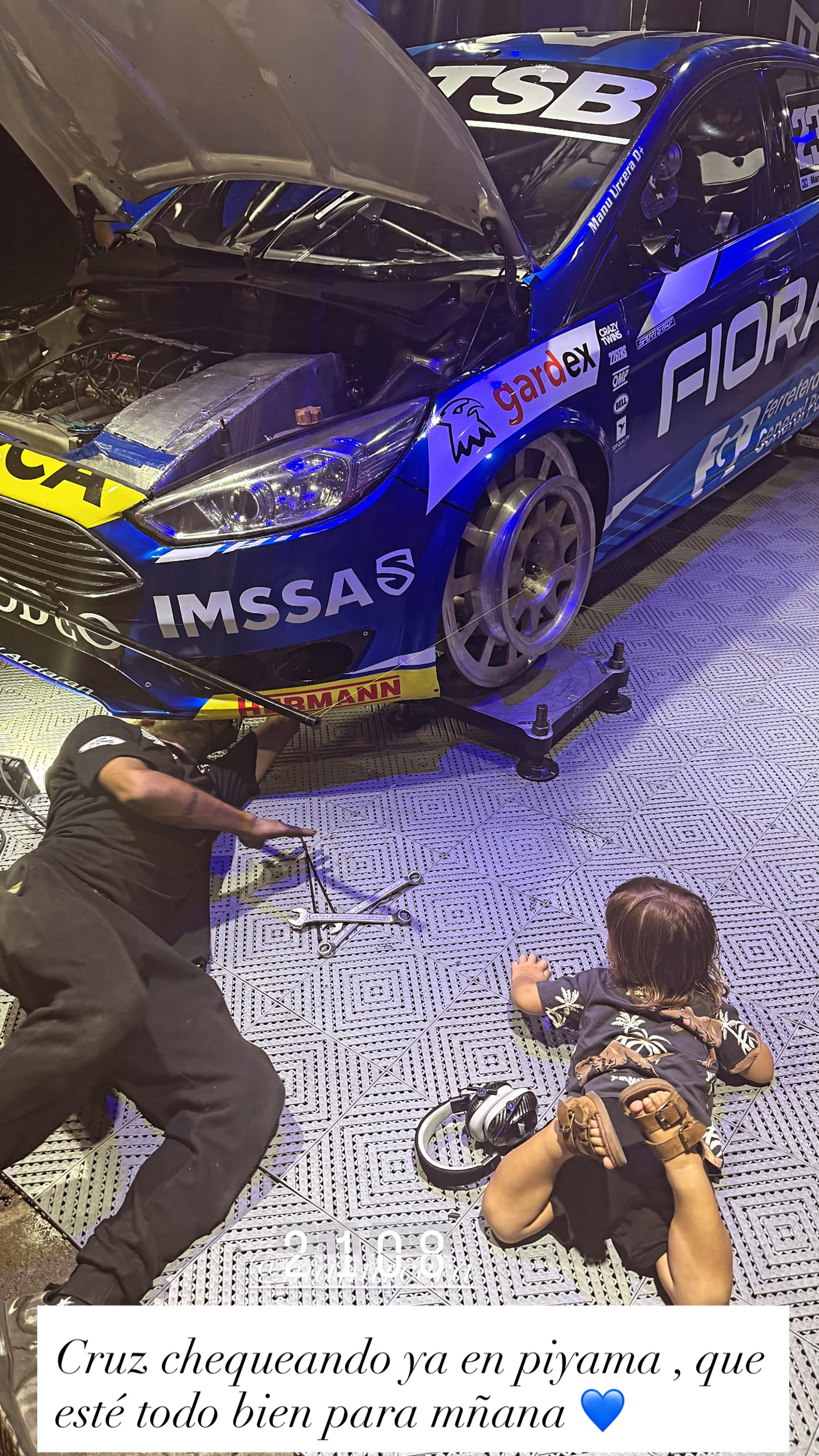 Cruz observa atentamente el trabajo del mecánico en el auto de competición 