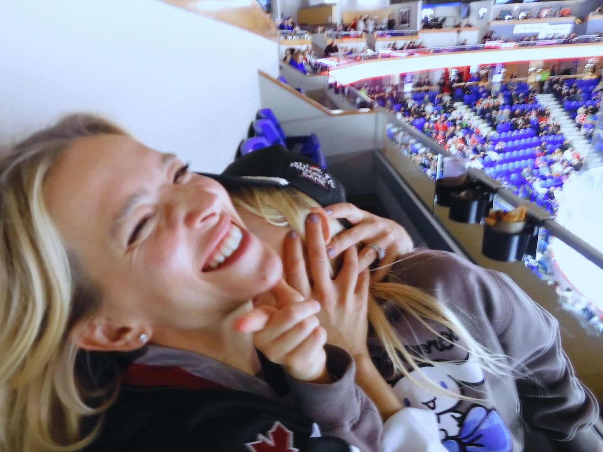 Luisana y su hija riendo a carcajadas en un estadio, disfrutando del evento deportivo
