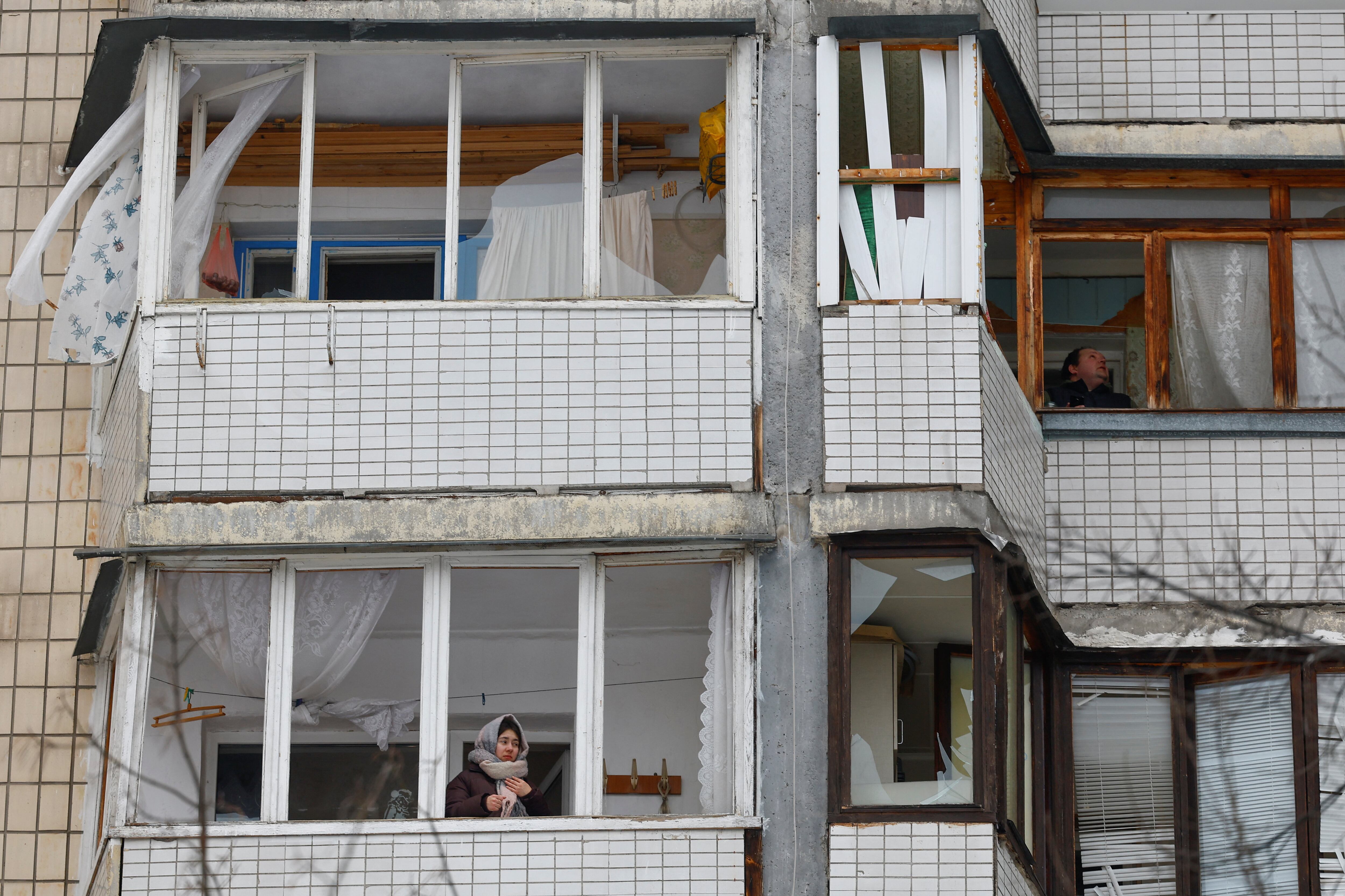 Una mujer observa desde la ventana de su apartamento tras un ataque ruso (REUTERS/Valentyn Ogirenko)
