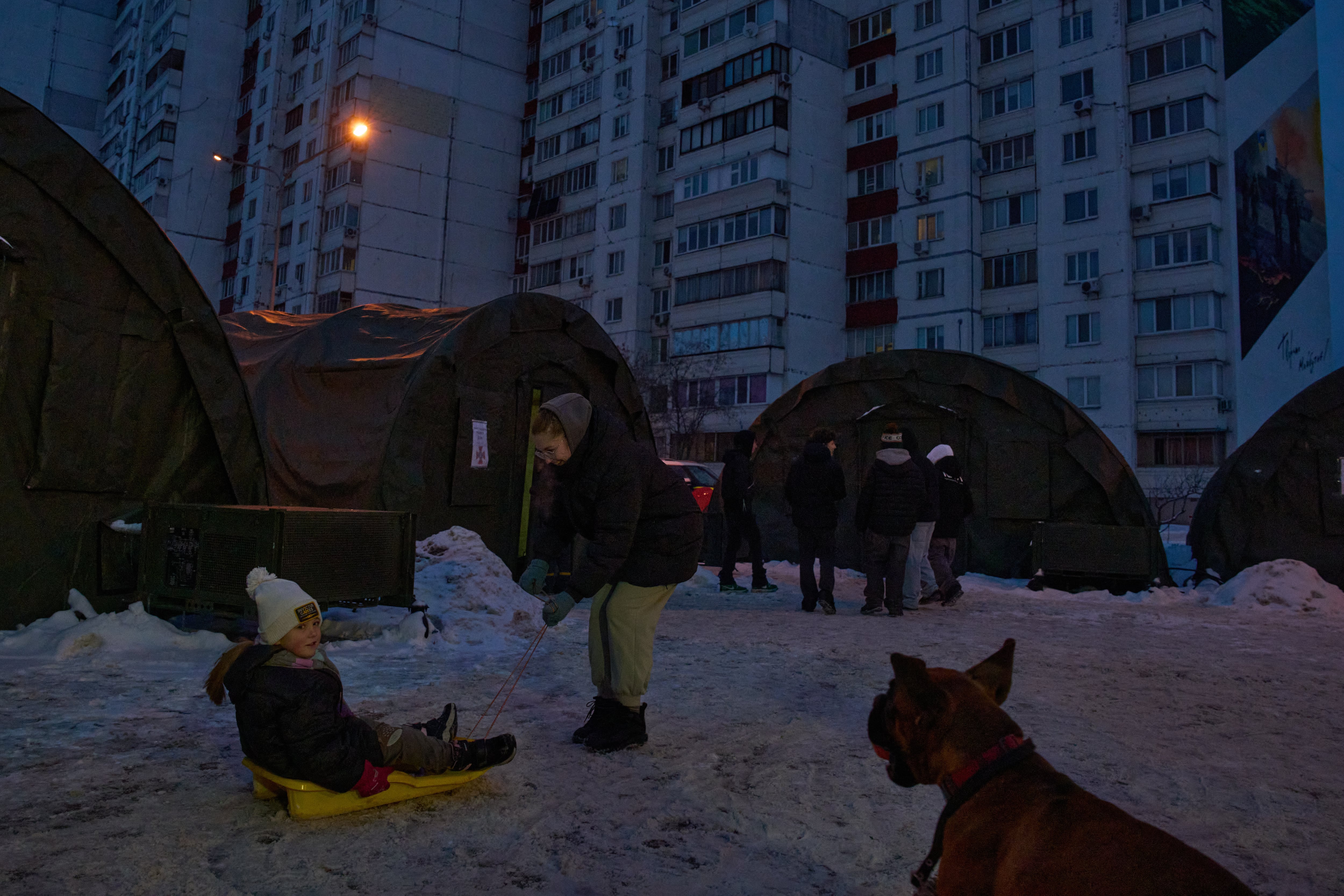 Unas niñas juegan en un trineo cerca de un campamento de tiendas de campaña de emergencia en un barrio residencial sin luz por los bombardeos rusos a las instalaciones eléctricas ucranianas, en Kiev, el 8 de febrero de 2026
(Foto AP/Efrem Lukatsky)