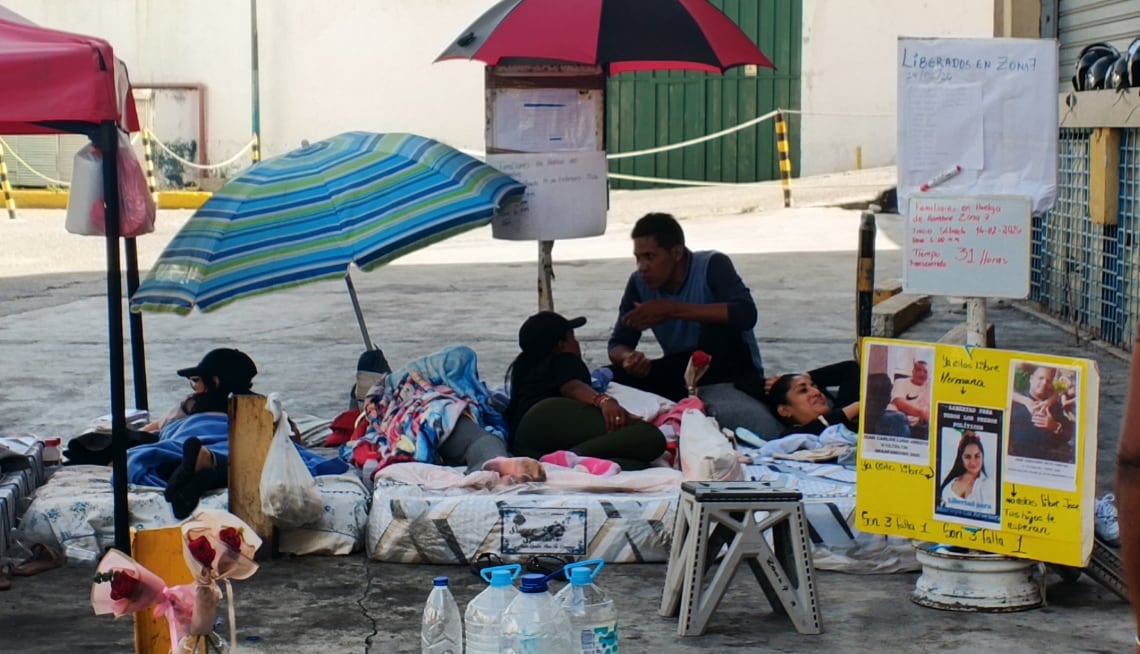 Familias de presos políticos mantienen una vigilia con colchones y sombrillas, esperando noticias sobre la liberación de sus seres queridos. (Fuente: Vente Venezuela)