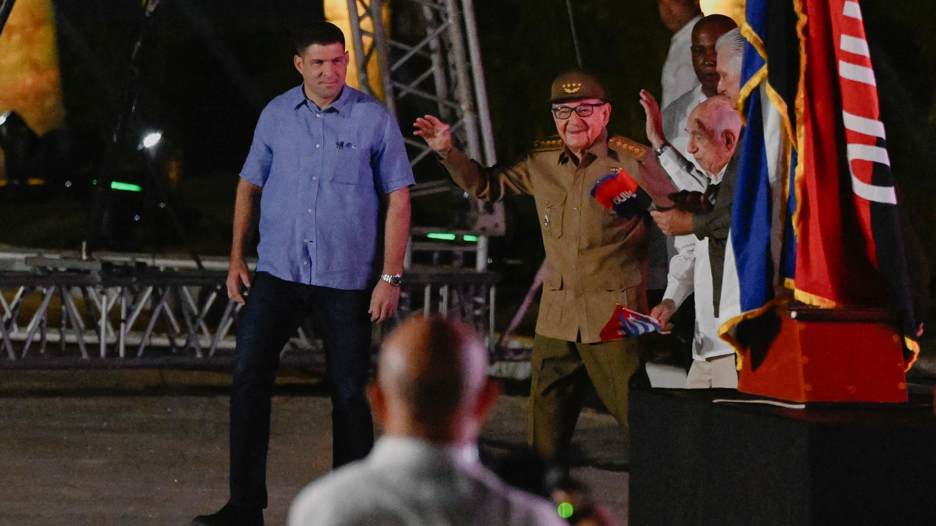 El dictador Raúl Castro de uniforme saluda en un acto en La Habana. A su lado, de camisa azul, su nieto Raúl Rodríguez Castro, consejero y guardaespaldas (Reuters)