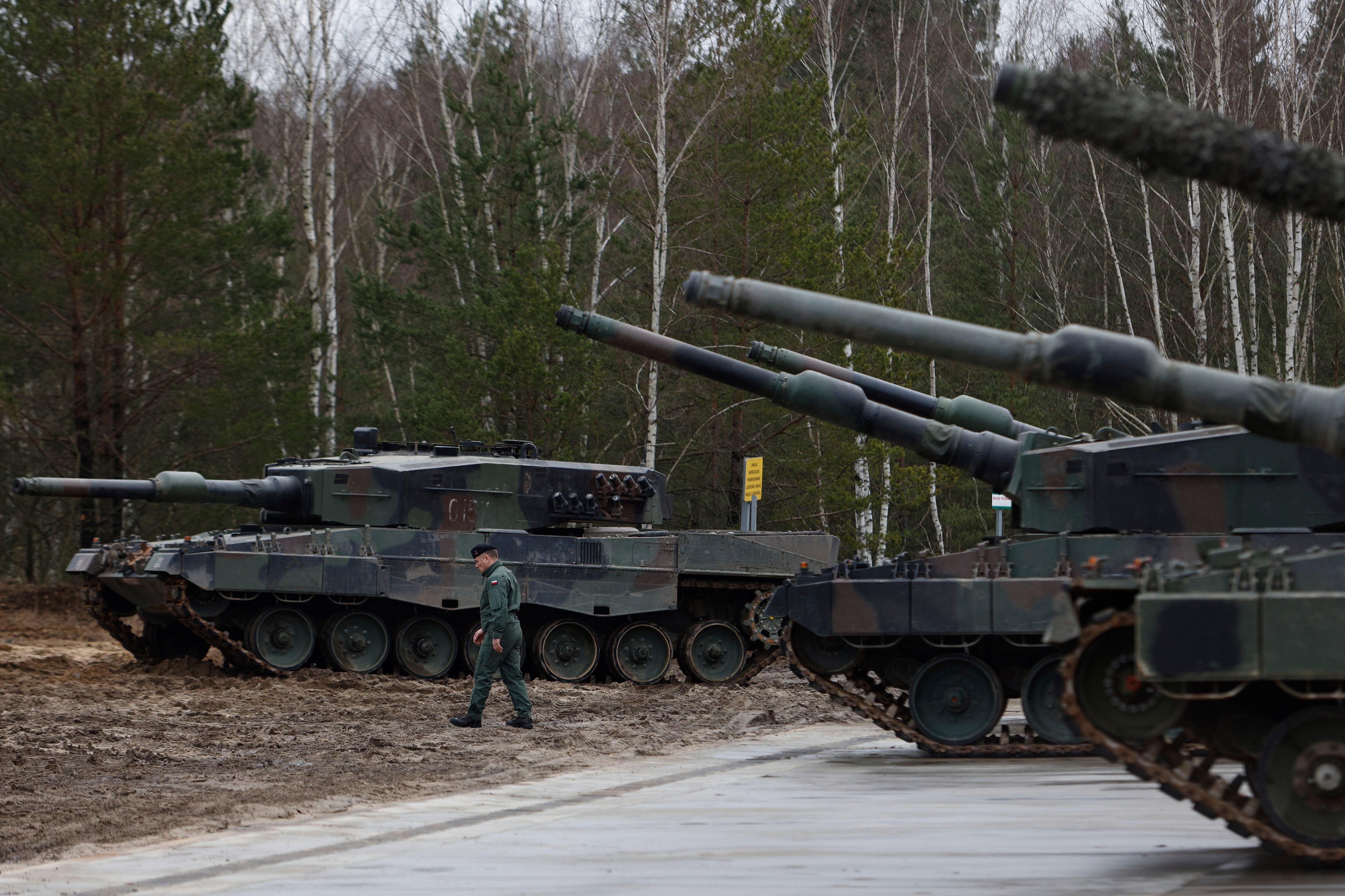 ARCHIVO – Un soldado polaco camina frente a dos tanques Leopard 2 en un entrenamiento en una base militar y campo de pruebas en Swietoszow, Polonia, el lunes 13 de febrero de 2023 (AP Foto/Michal Dyjuk, Archivo)