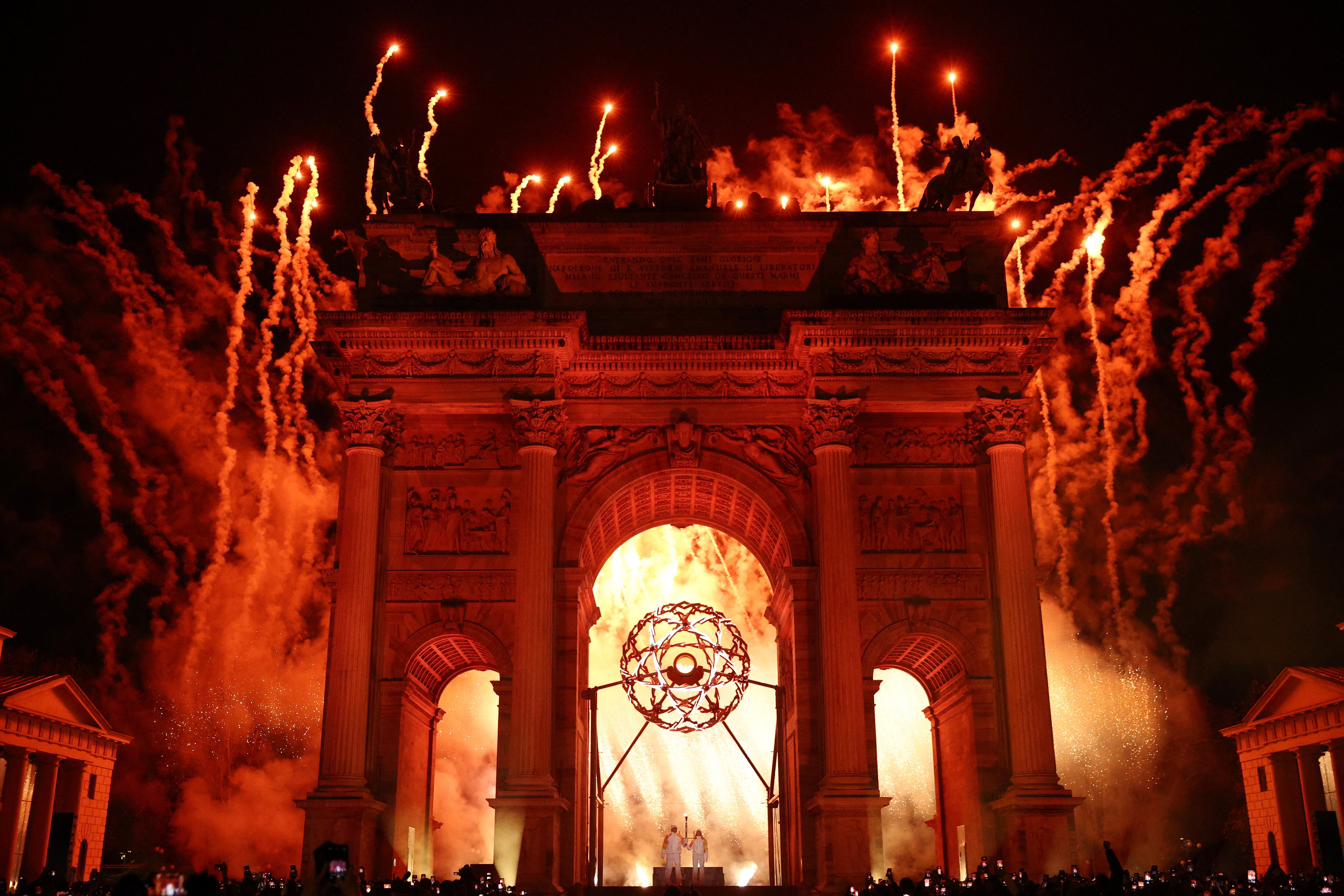El instante preciso que Alberto Tomba y Deborah Compagnoni encendieron el pebetero olímpico bajo el Arco della Pace en Milán (Crédito: Reuters/Guglielmo Mangiapane)