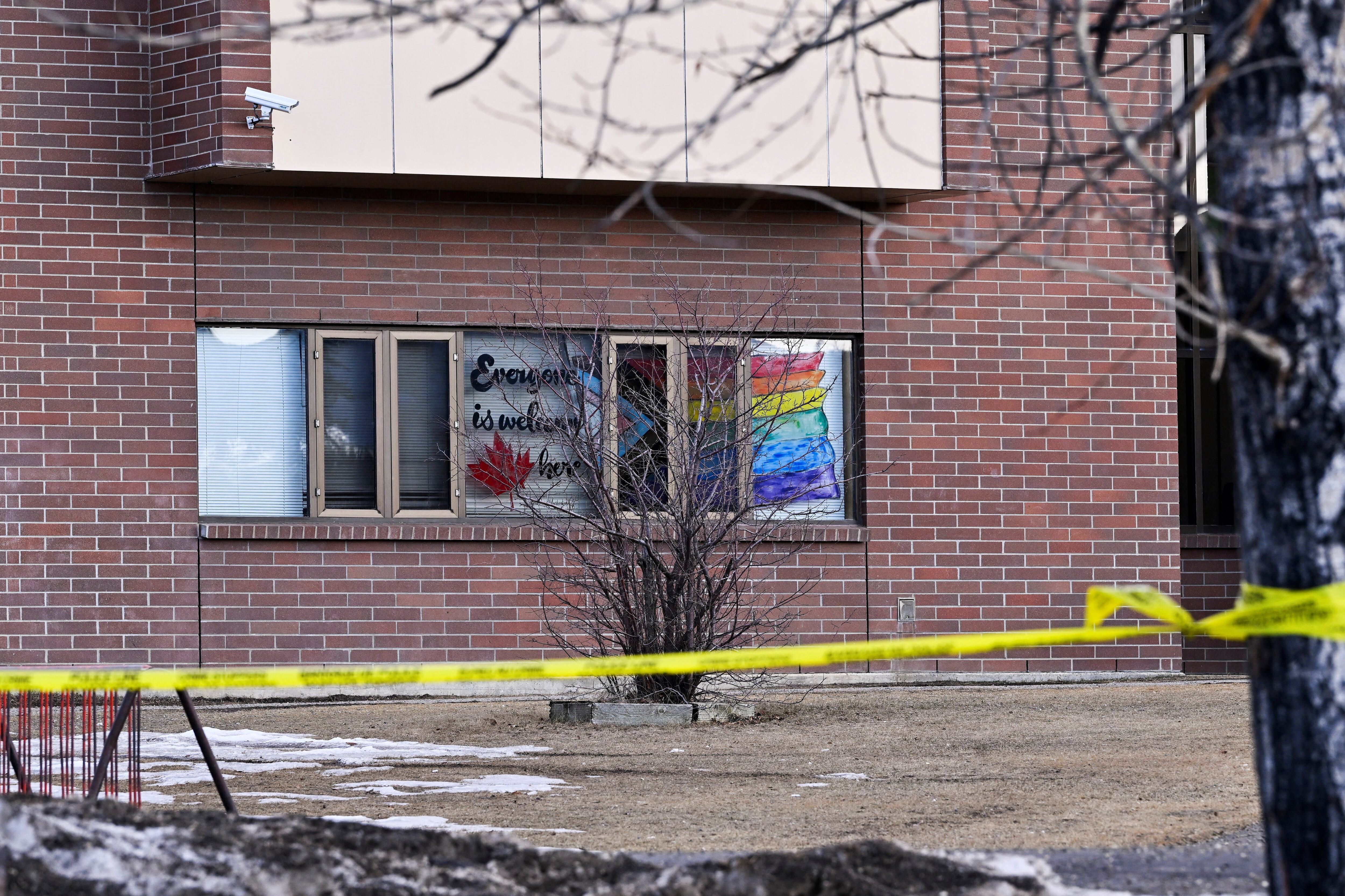La cinta de la escena del crimen rodea una escuela secundaria con una bandera del Orgullo pintada en una ventana, en el lugar de un tiroteo masivo mortal en la ciudad de Tumbler Ridge, Columbia Británica, Canadá, el 11 de febrero de 2026. REUTERS/Jennifer Gauthier