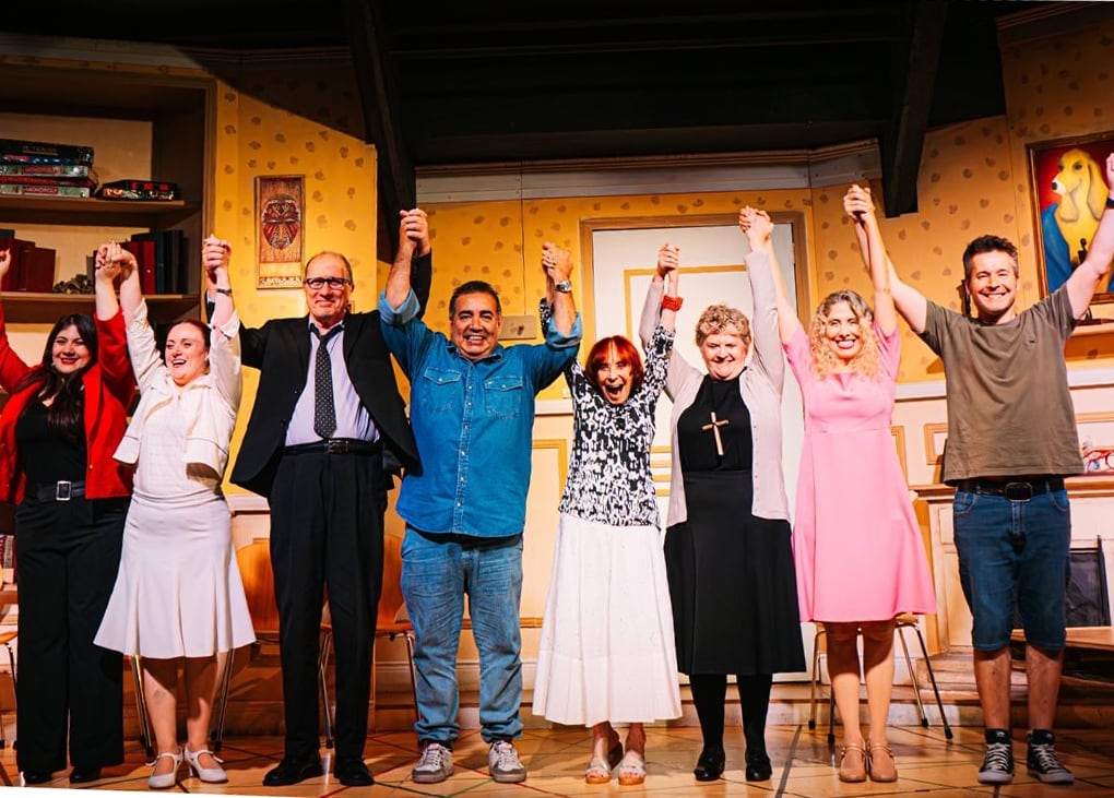 Los actores de la obra TocToc, visiblemente felices, saludan al público con los brazos alzados en el escenario al final de su exitosa función.