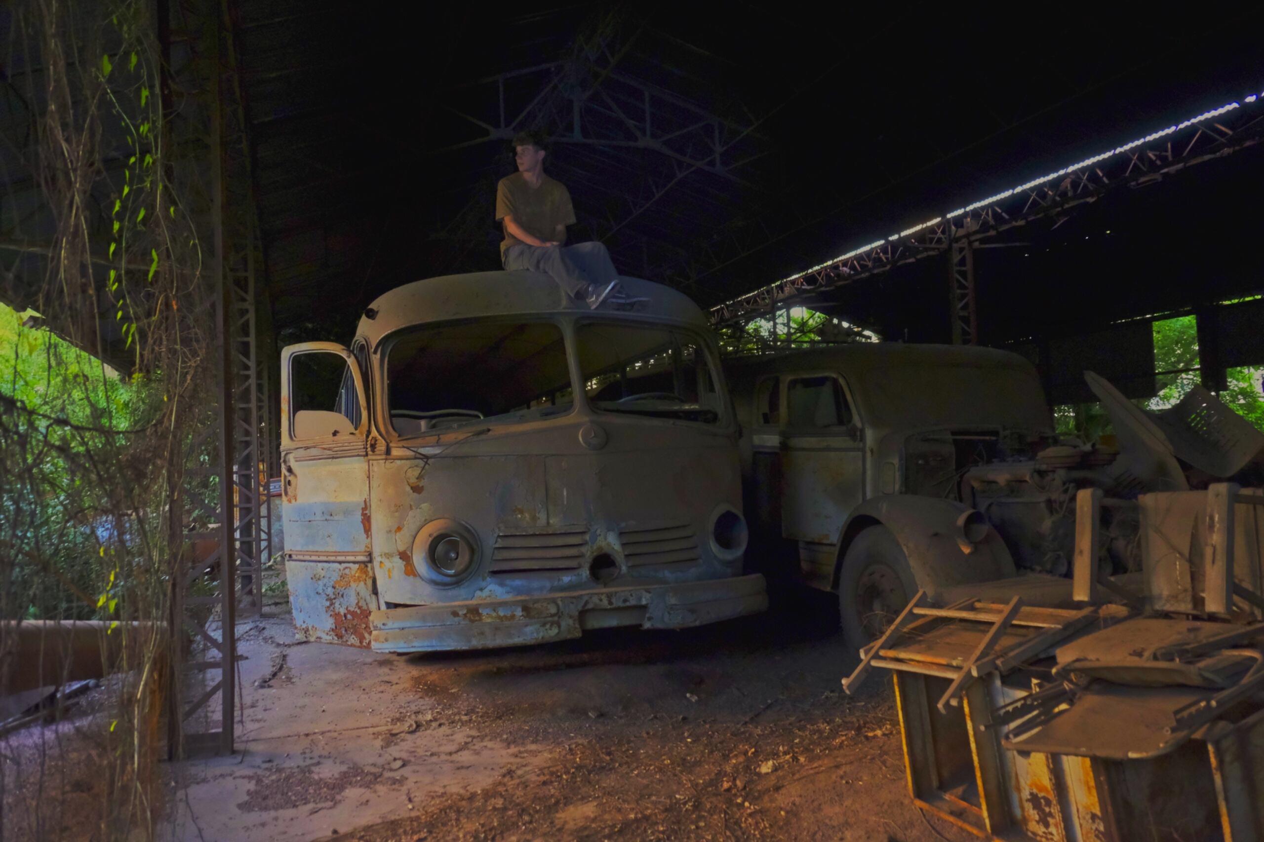 Ian Menéndez sobre un colectivo abandonado dentro de una fábrica