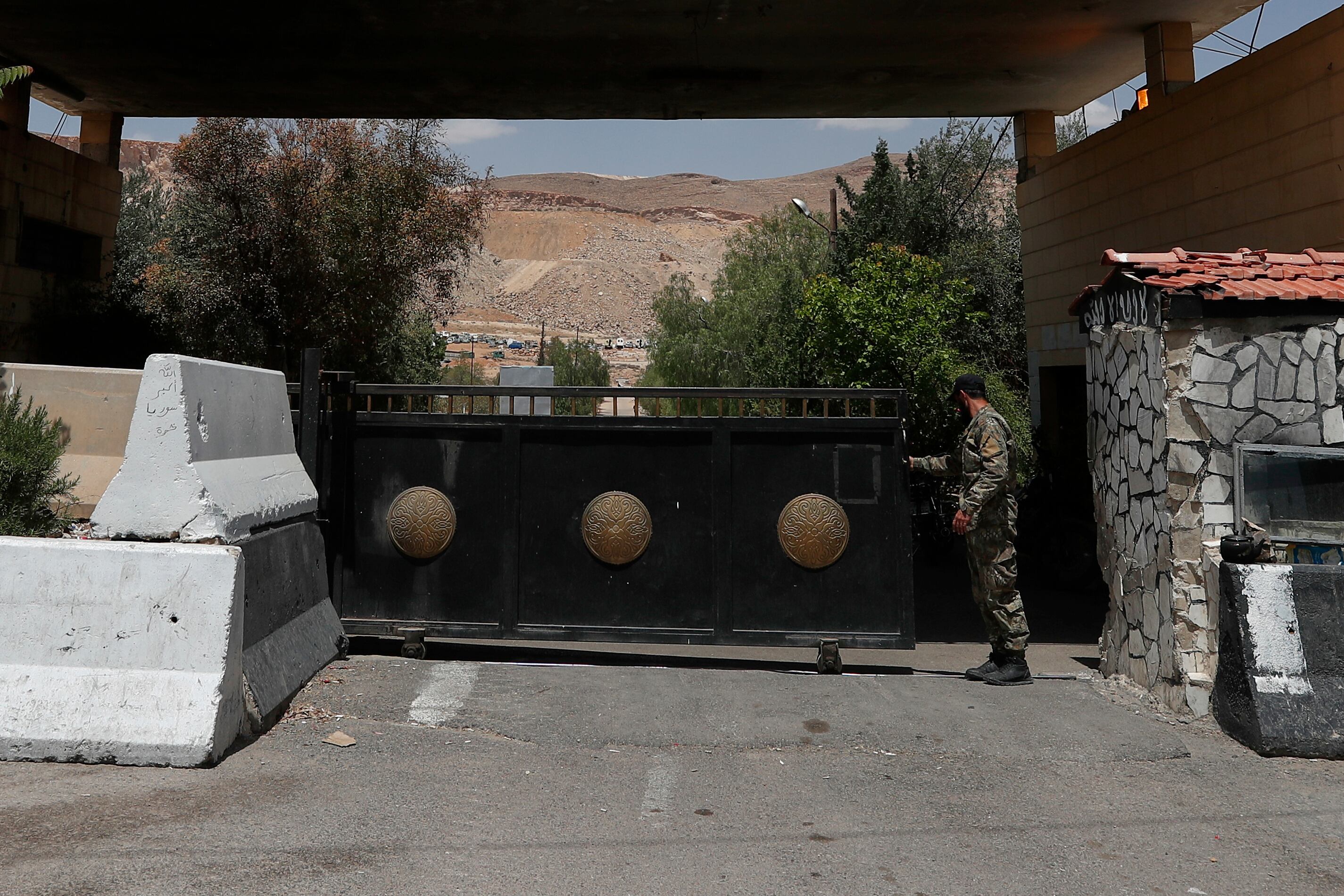 Un soldado sirio cierra la puerta de acceso a una base militar a las afueras de Harasta, cerca de Damasco, Siria, el 3 de mayo de 2025 (AP Foto/Omar Sanadiki)