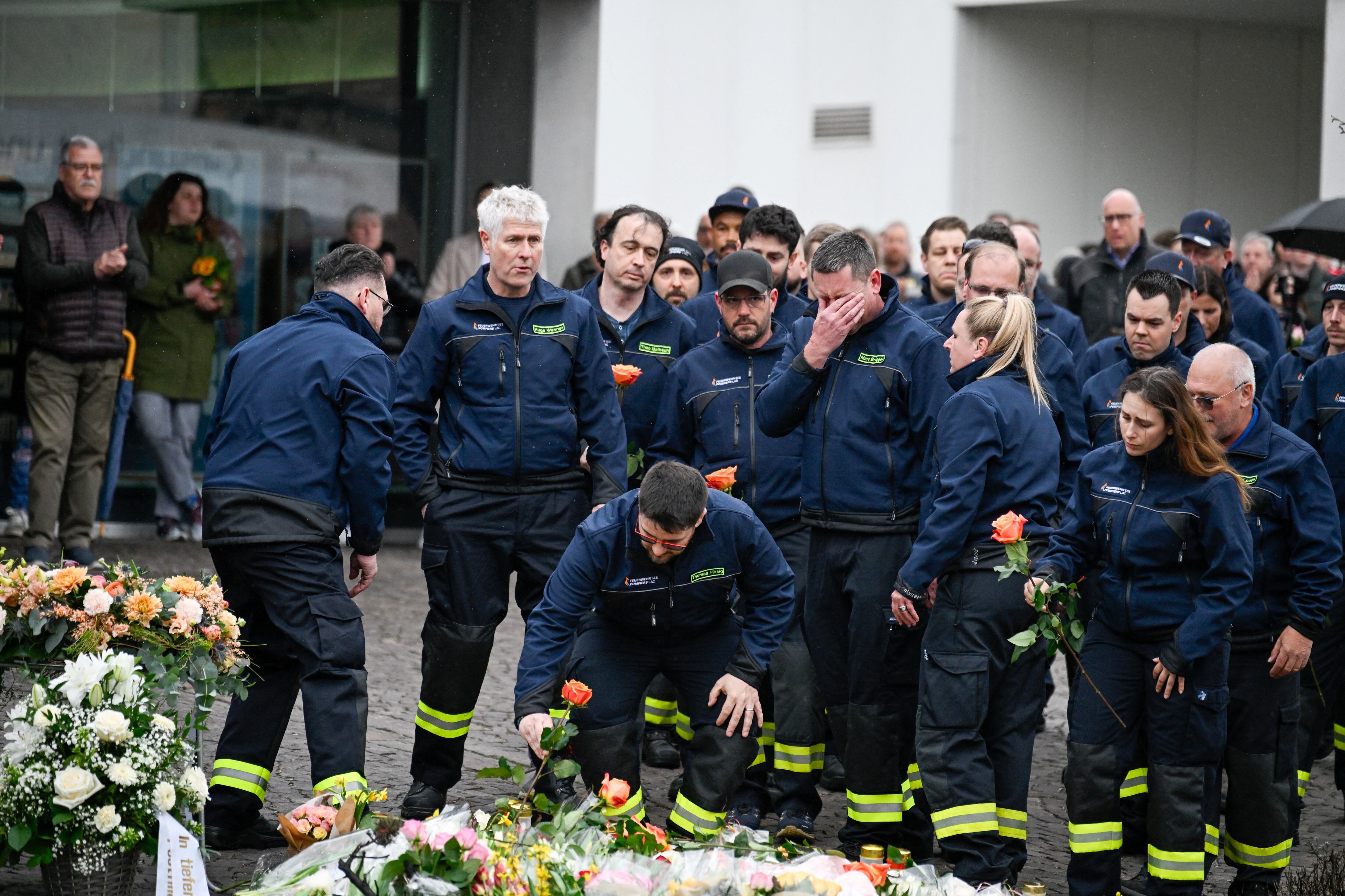 Los bomberos depositan flores como homenaje en el lugar del mortal incendio de un autobús en Kerzers, Suiza, el 11 de marzo de 2026. REUTERS/Romina Amato
