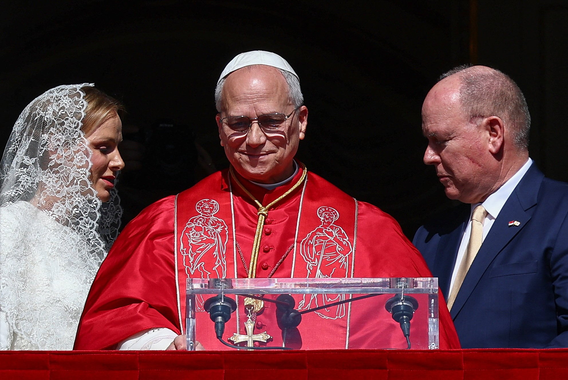 El príncipe Alberto II de Mónaco, la princesa Charlene y el papa León XIV se asoman a un balcón del Palacio del Príncipe durante la visita de un día del Papa a Mónaco, el 28 de marzo de 2026. REUTERS/Guglielmo Mangiapane