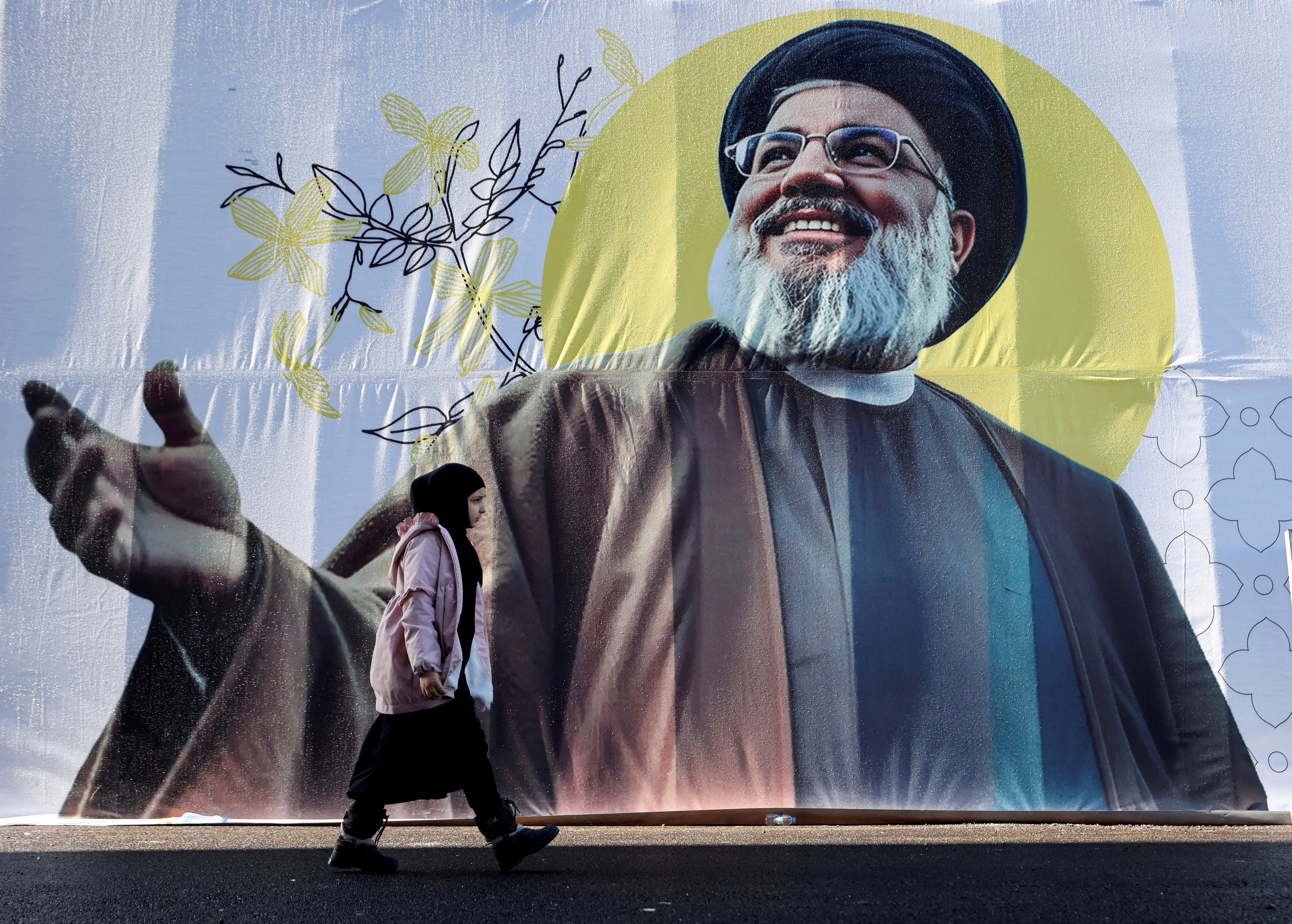 Una niña pasa junto a una imagen de Hassan Nasrallah, quien fue abatido durante bombardeos israelíes en Beirut el año pasado (REUTERS/Mohamed Abd El Ghany/Foto de archivo) 