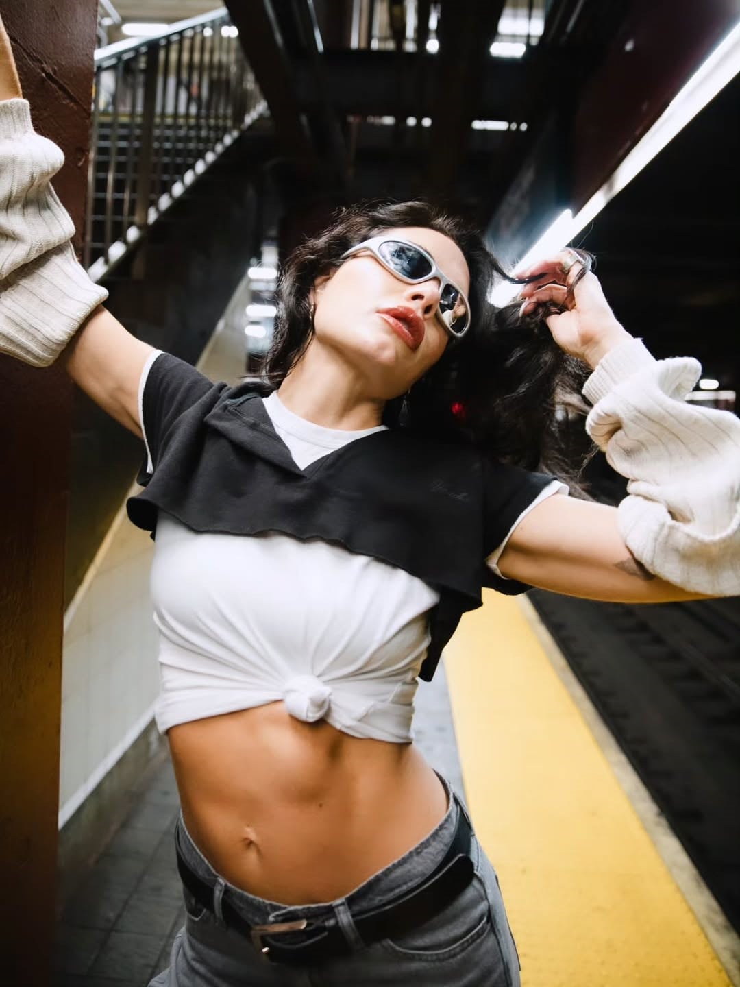 Remera blanca atada, micro croptop negro y mangas de lana 