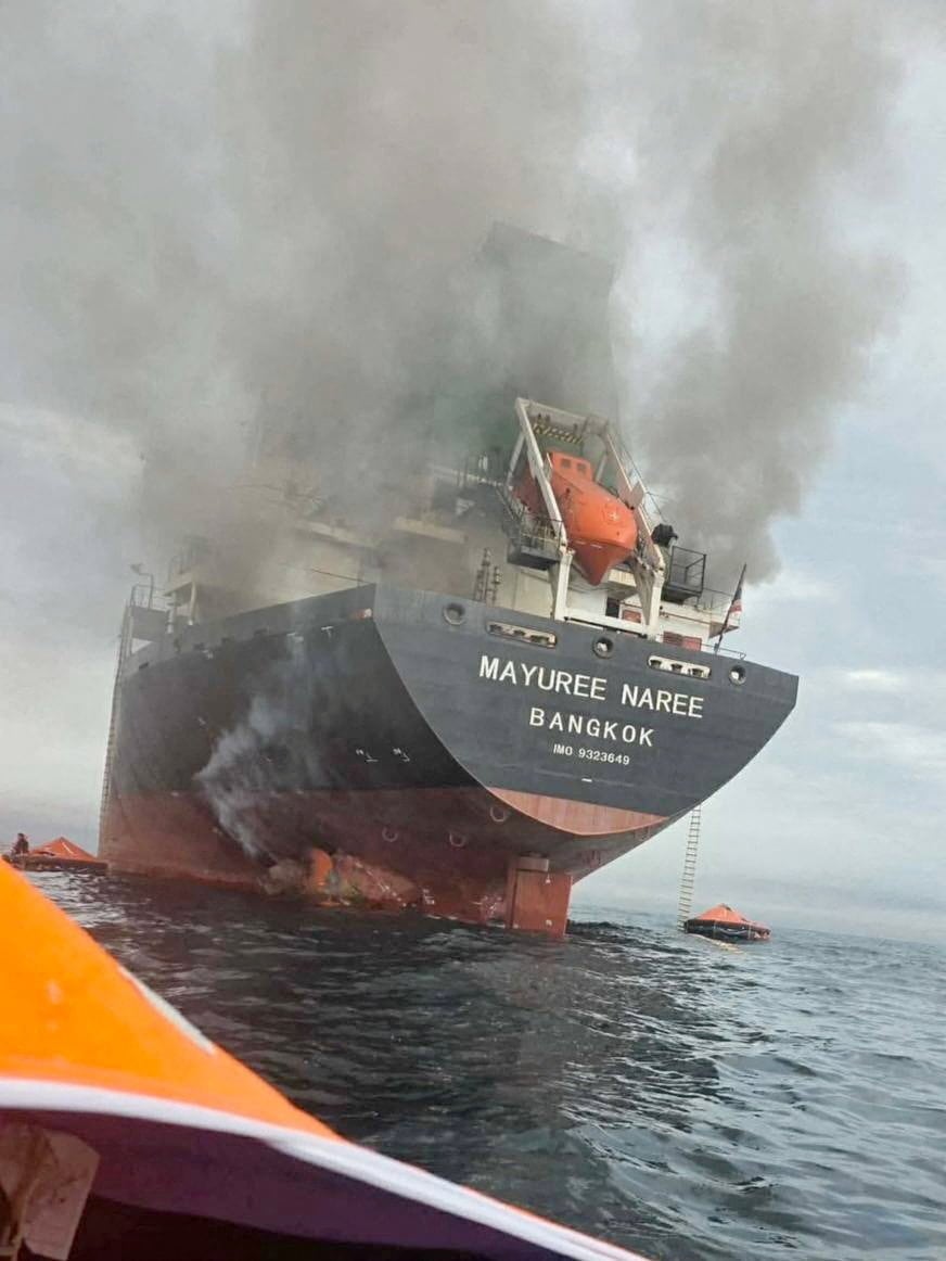 El buque de carga Mayuree Naree, con bandera tailandesa, envuelto en humo negro en el estrecho de Ormuz (REUTERS)